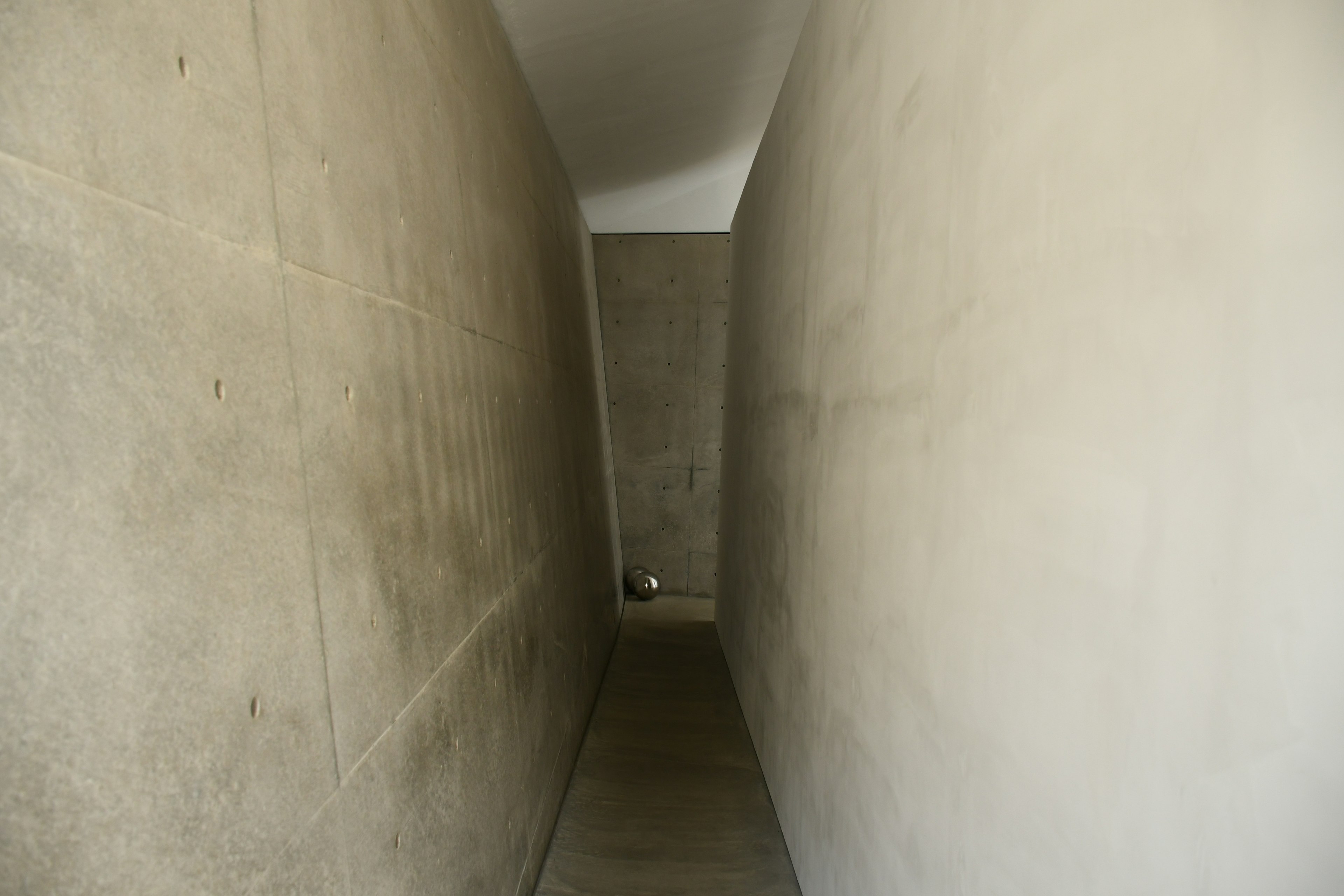 Couloir étroit en béton avec des murs lisses