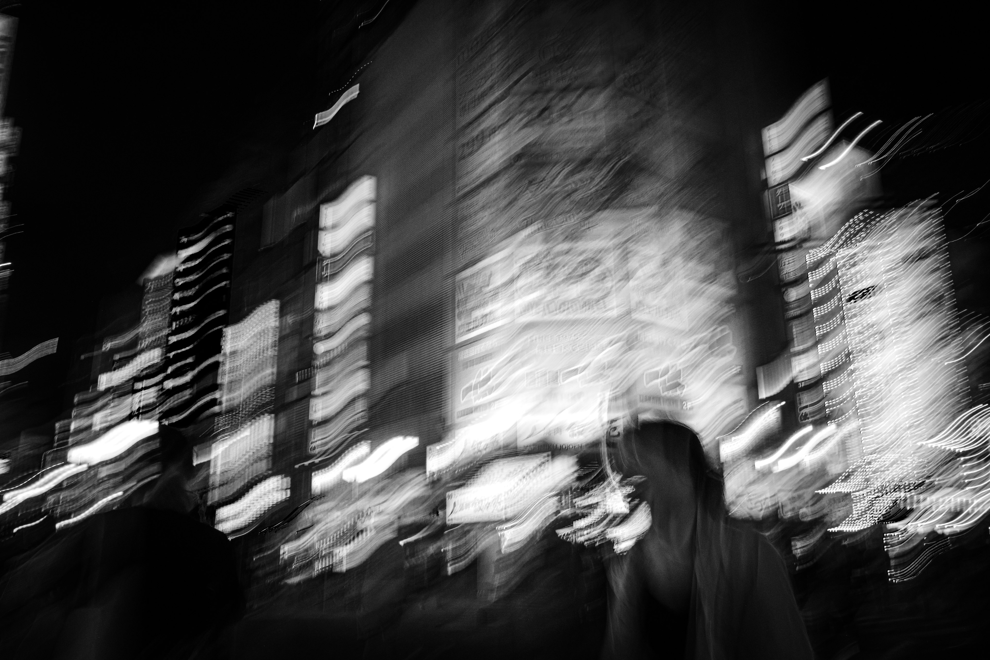 Blurred nighttime cityscape with silhouettes of people