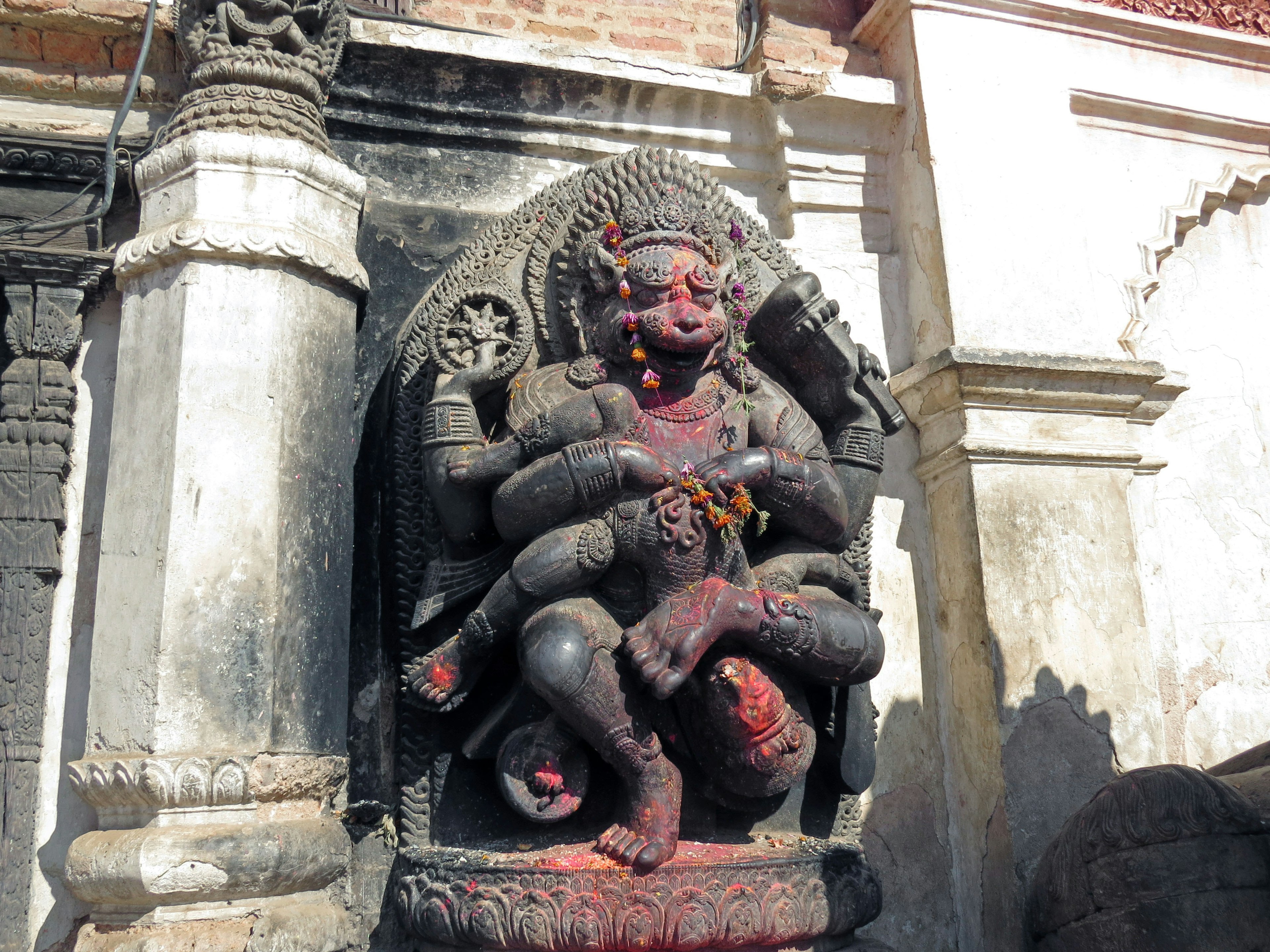 Sculpture d'une divinité hindoue avec plusieurs bras et détails complexes