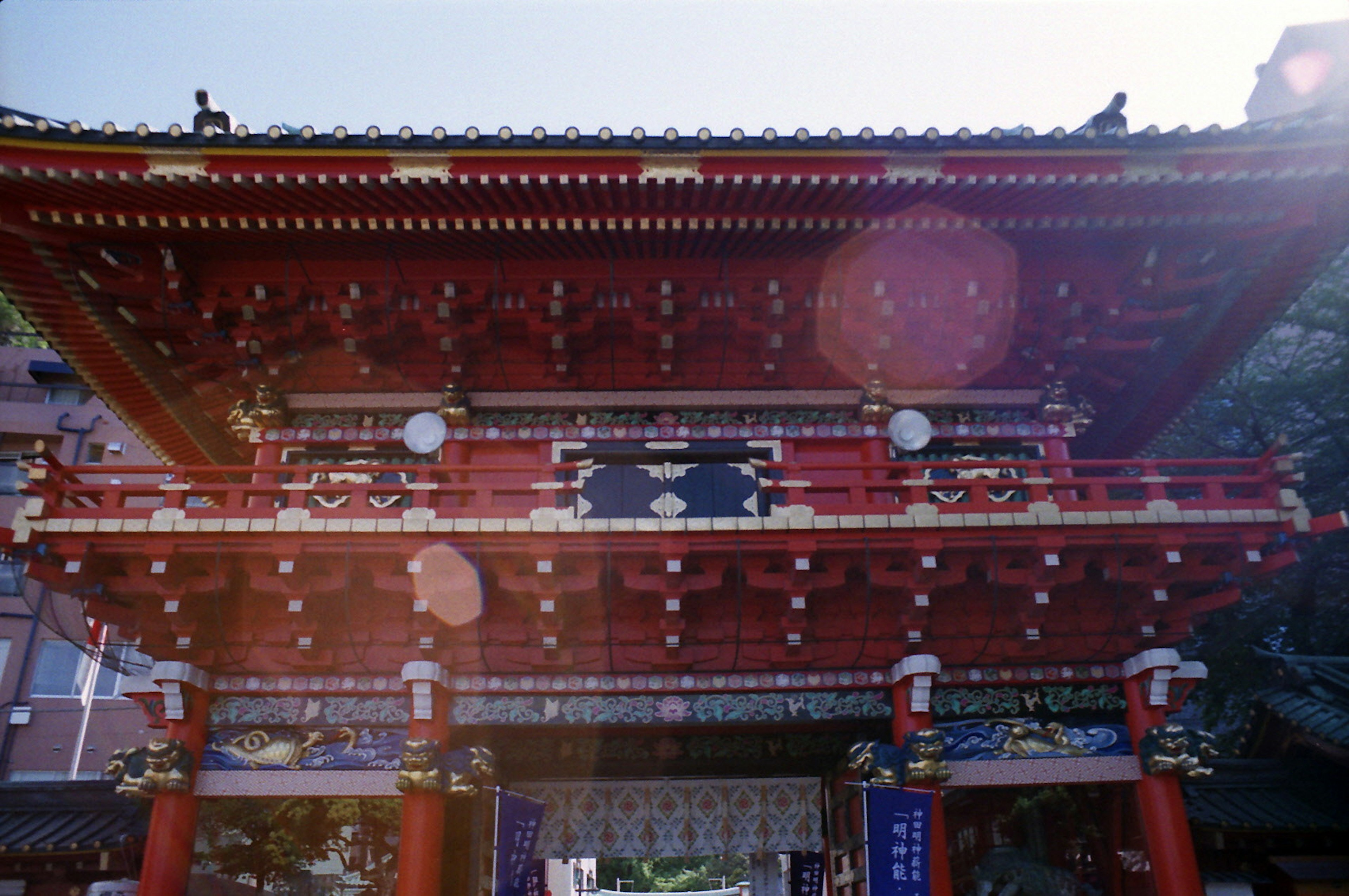 紅色屋頂的神社門裝飾雕刻明亮的陽光和藍色天空背景