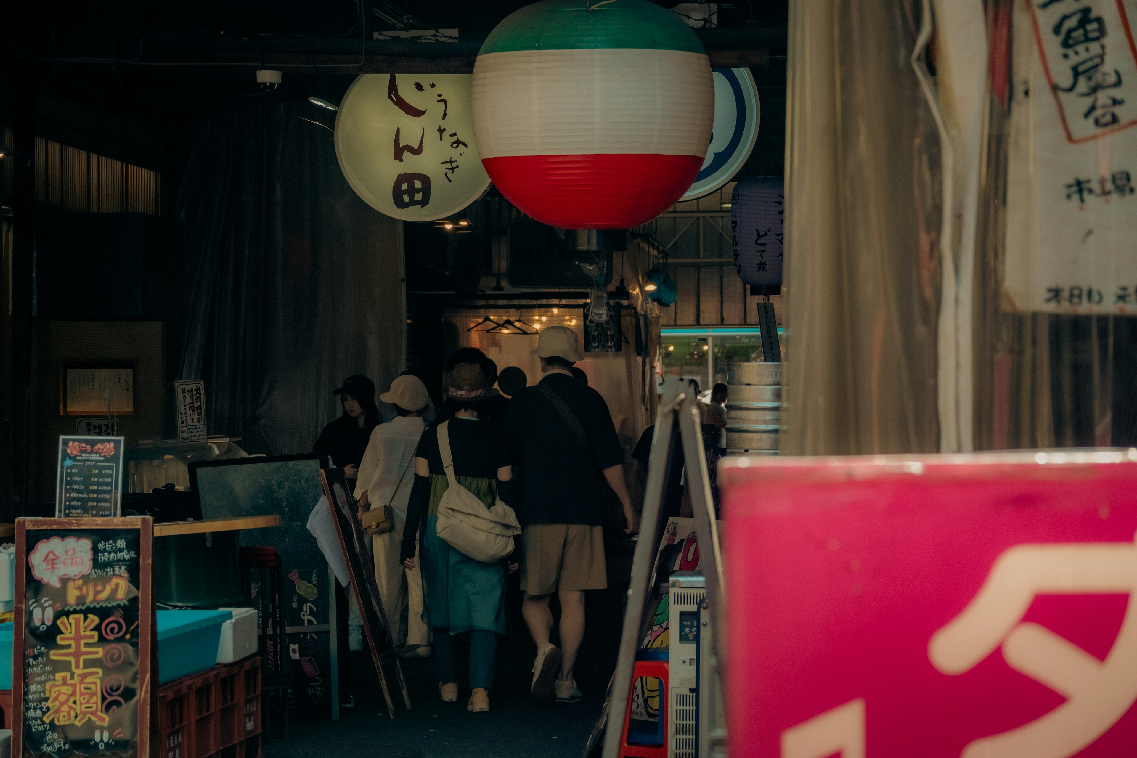 Colorful lanterns and people at the entrance of a lively street