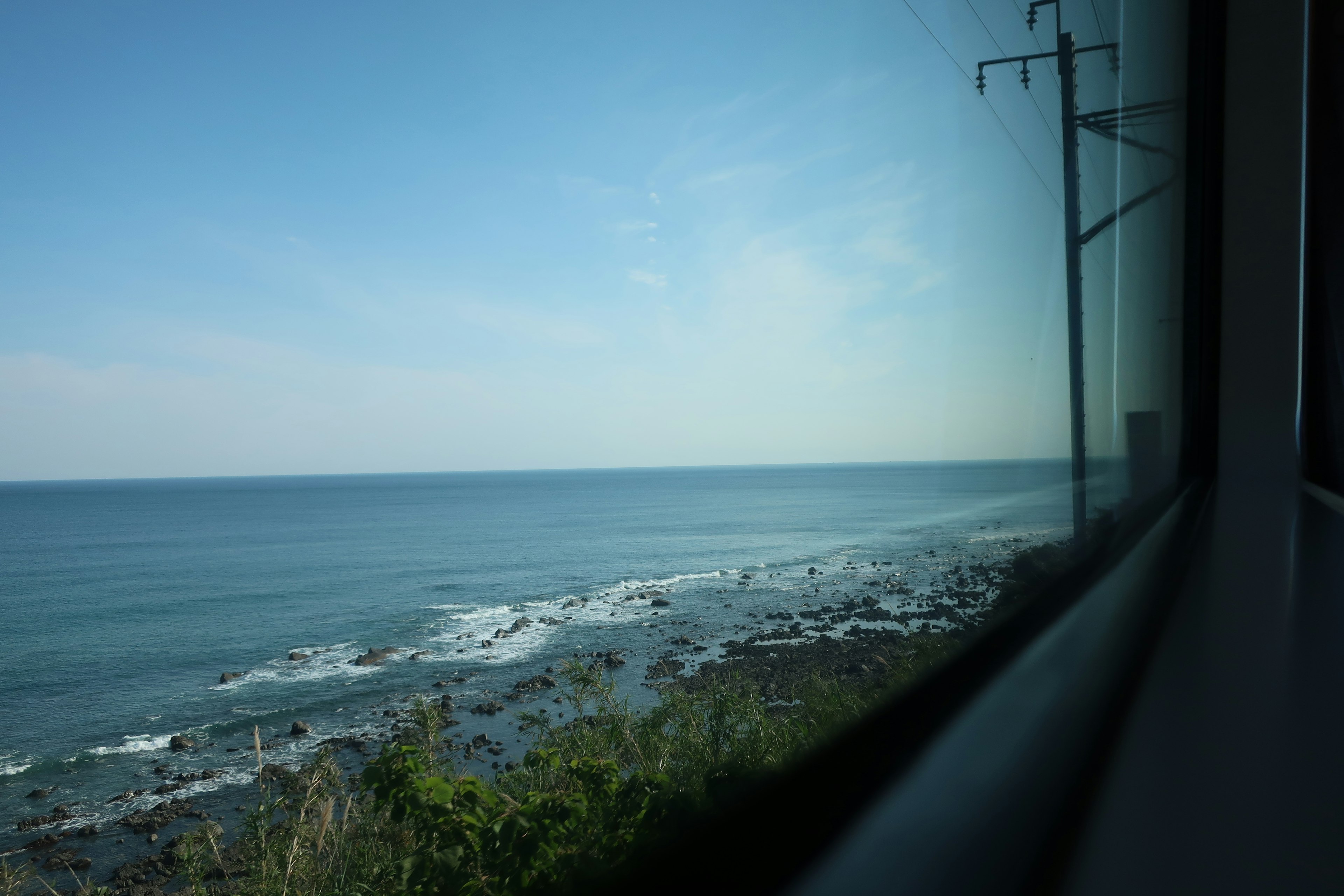 Vista della costa e del cielo blu da una finestra