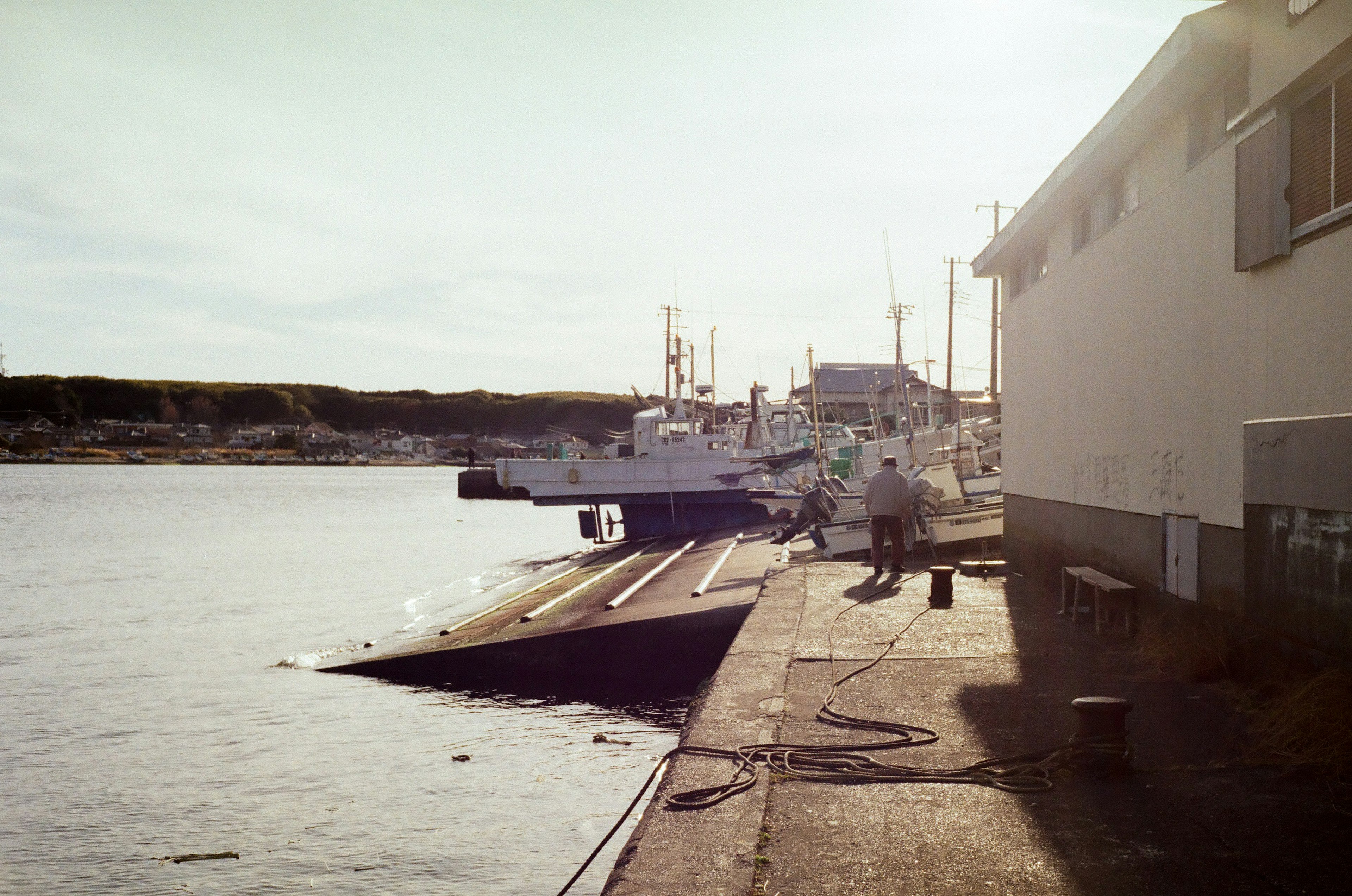 Escena de puerto tranquila con barcos y un muelle