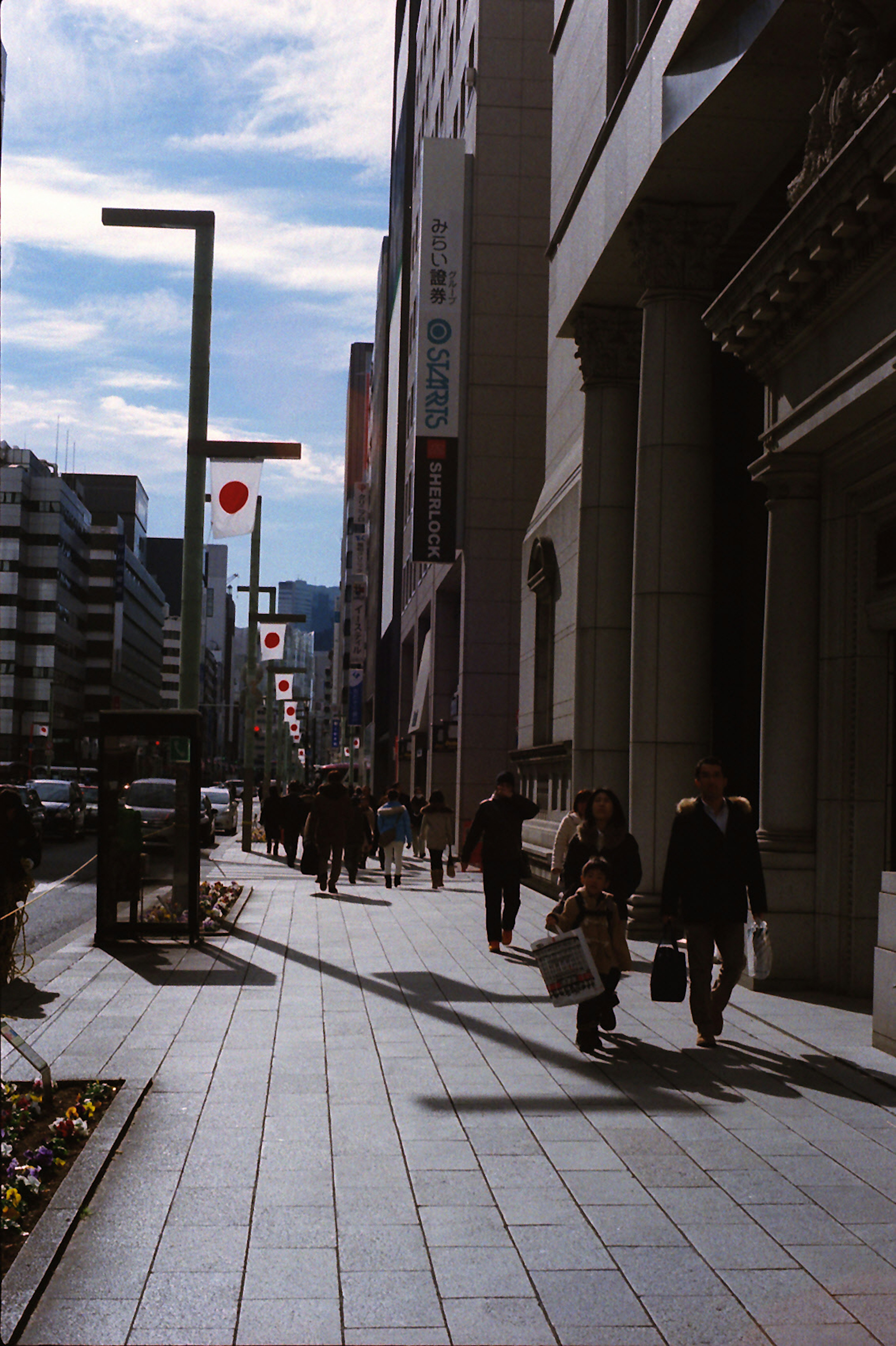 People walking on a city street with high-rise buildings