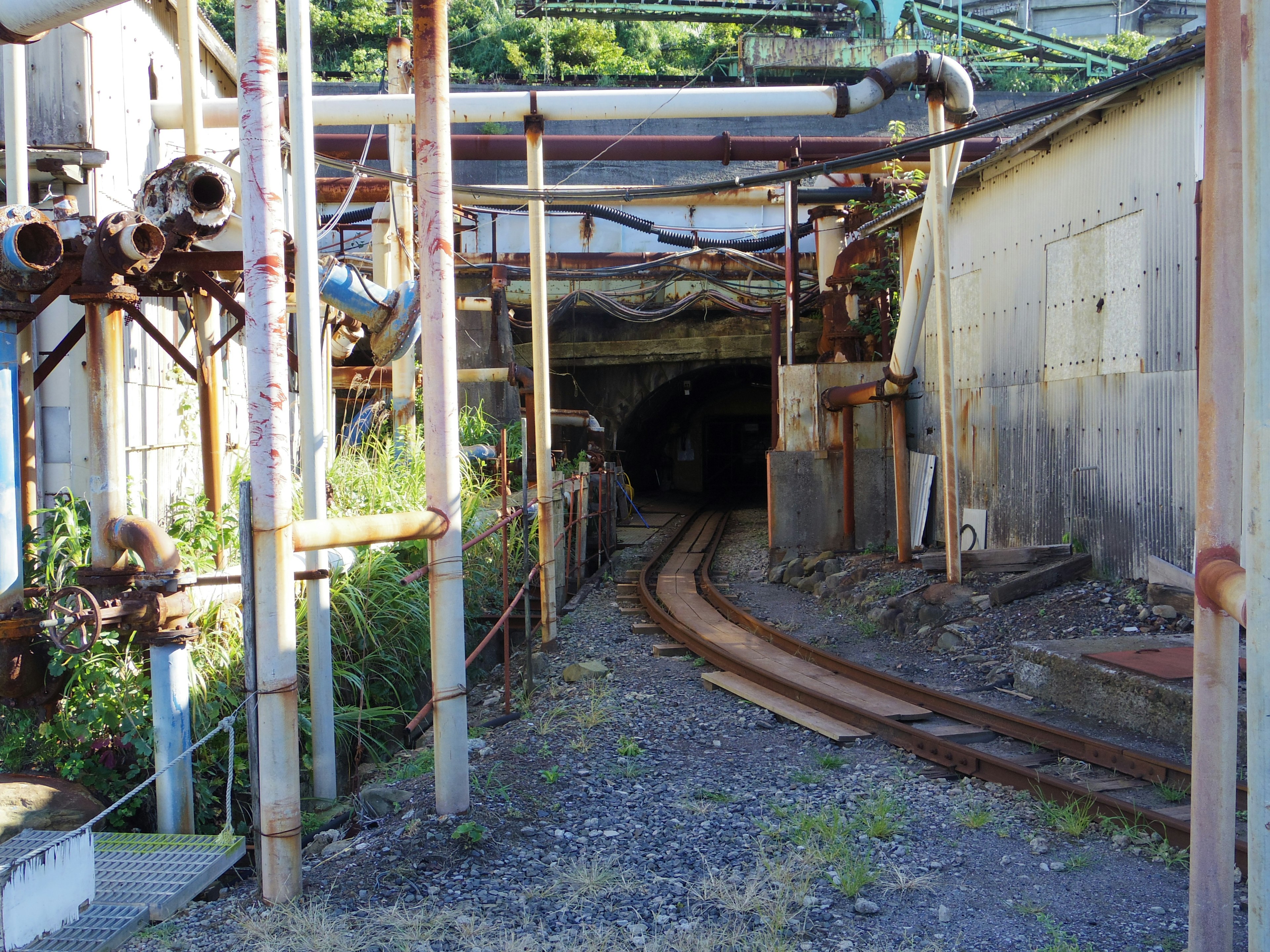 Image d'un ancien tunnel d'usine avec des voies ferrées courbes