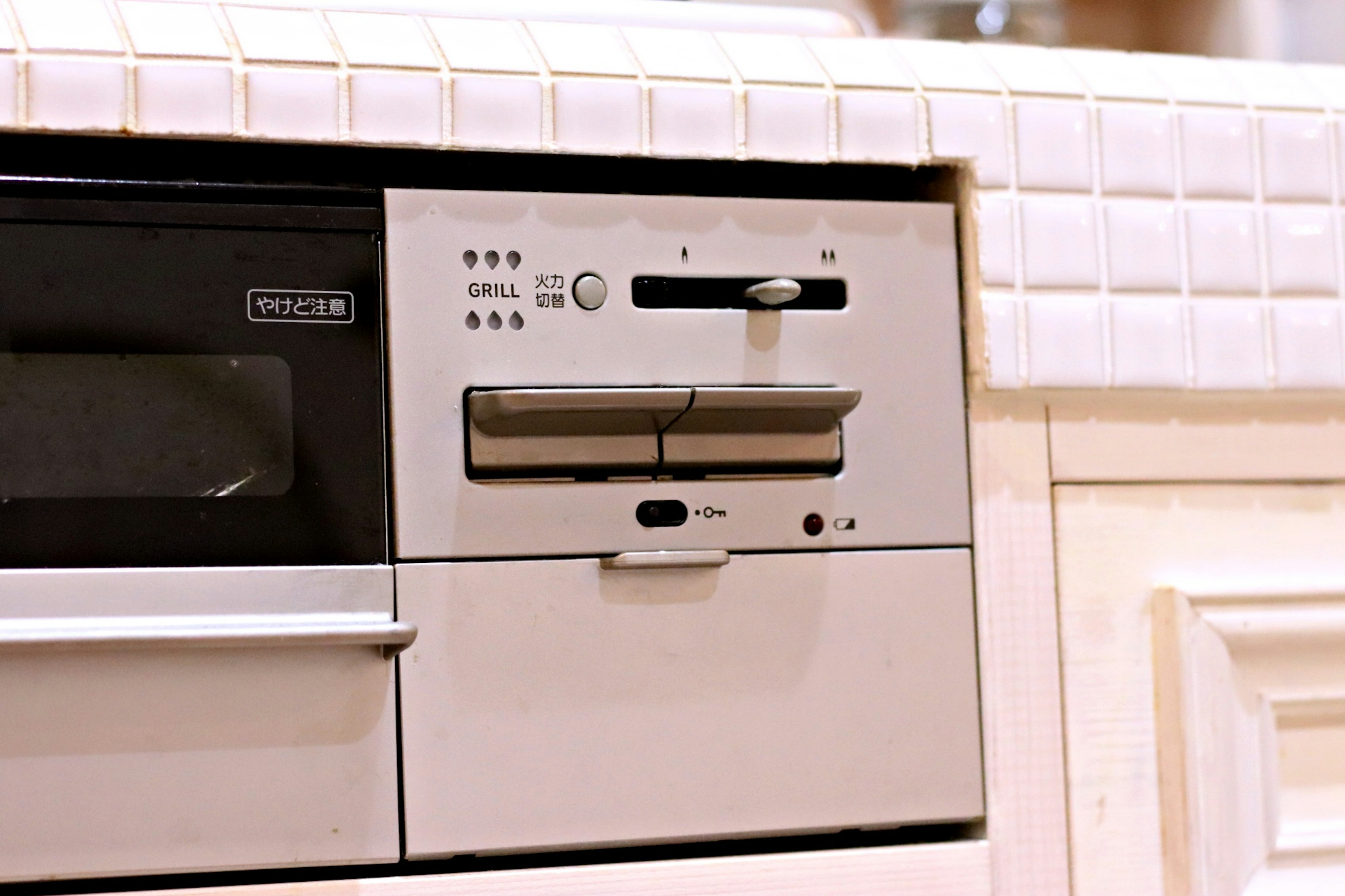 Control panel of a white kitchen appliance with a sliding door