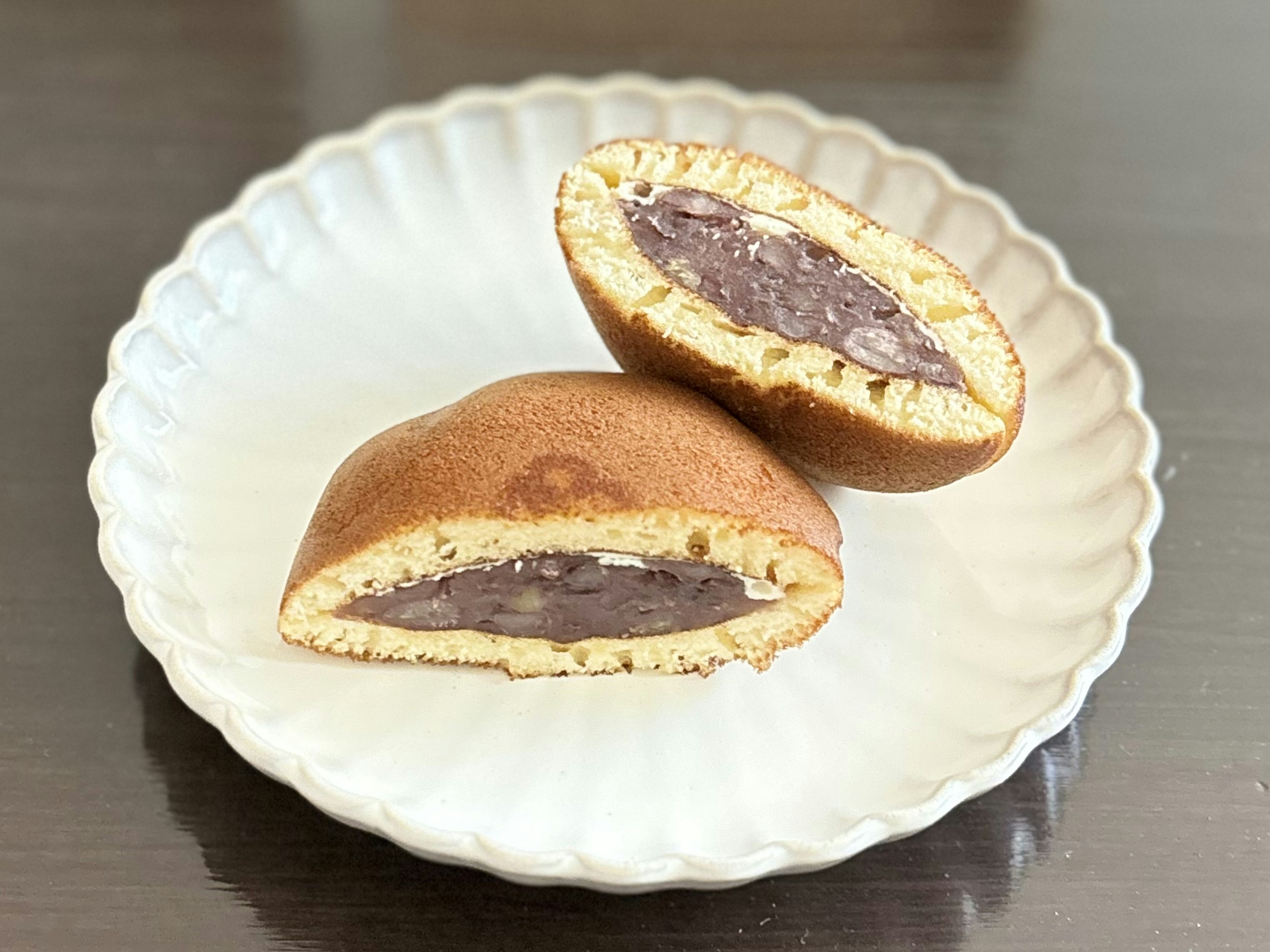 あんこが入った和菓子の半分が切られた状態で白い皿に載っている