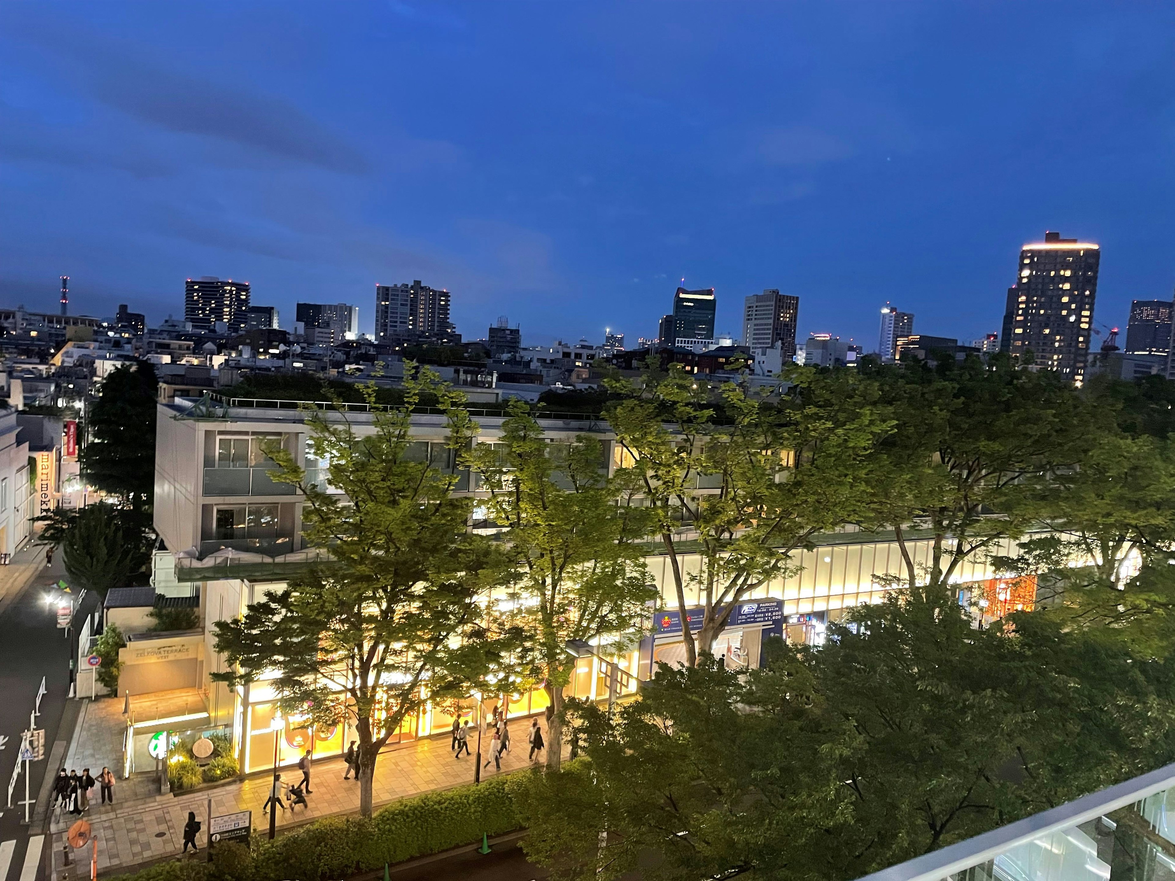 Tokyo cityscape at night with vibrant streets and greenery