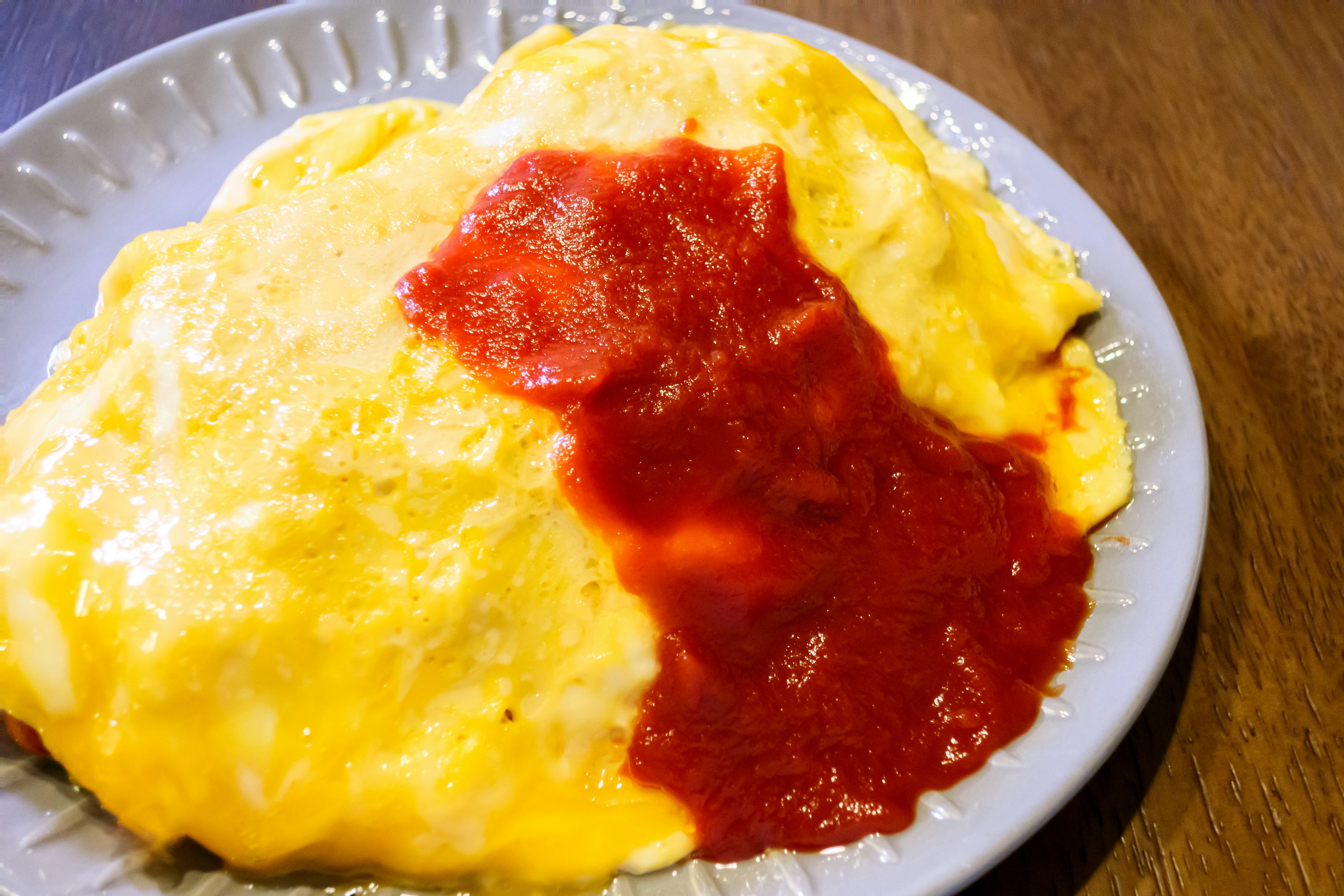 Arroz omelette con ketchup rojo en un plato