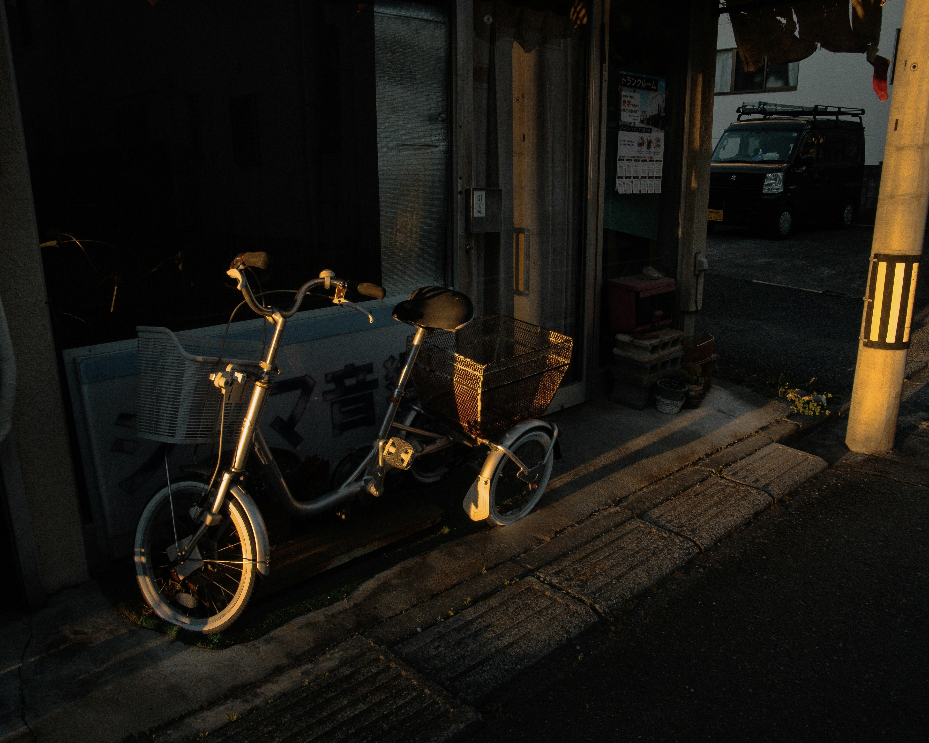 夕暮れの街角に置かれた電動自転車