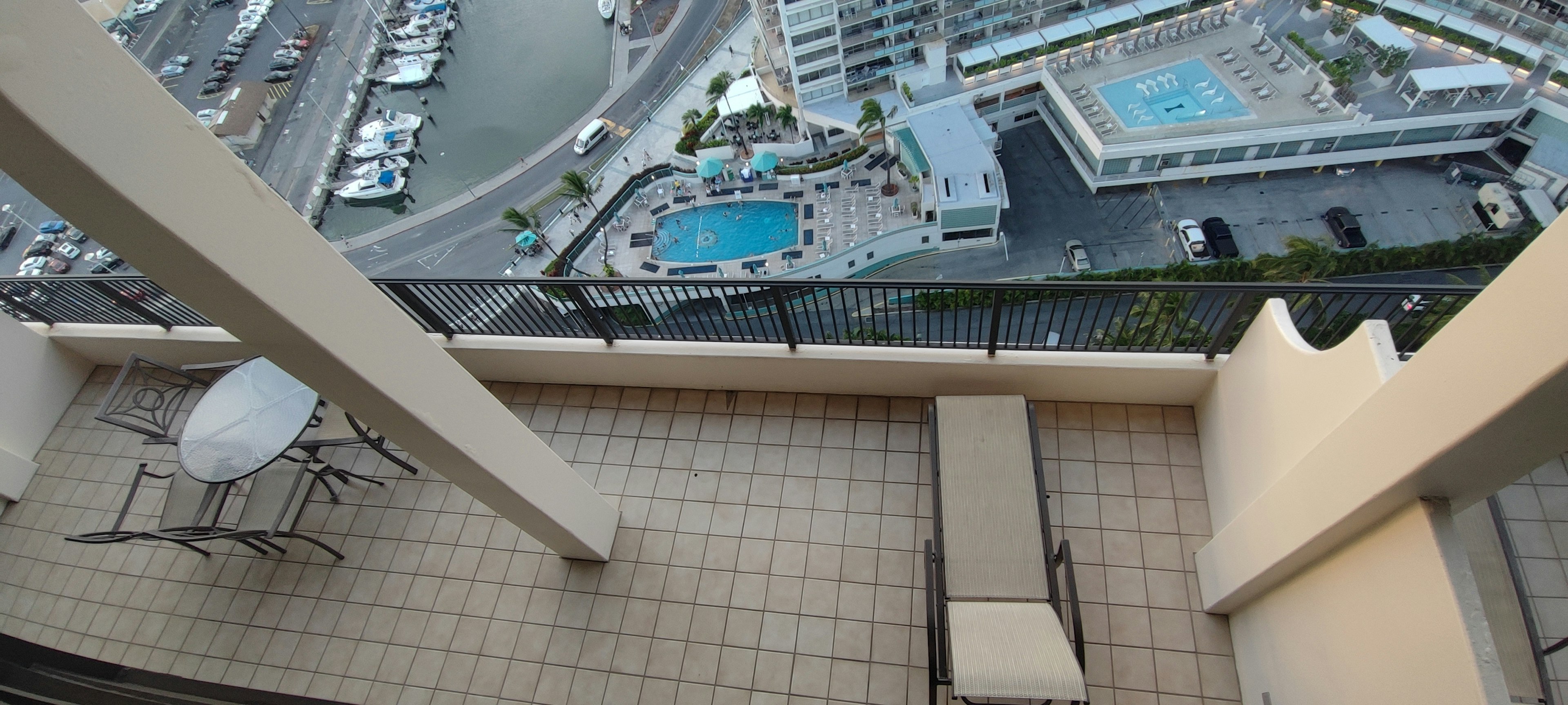 View from a high-rise balcony overlooking pools and marina