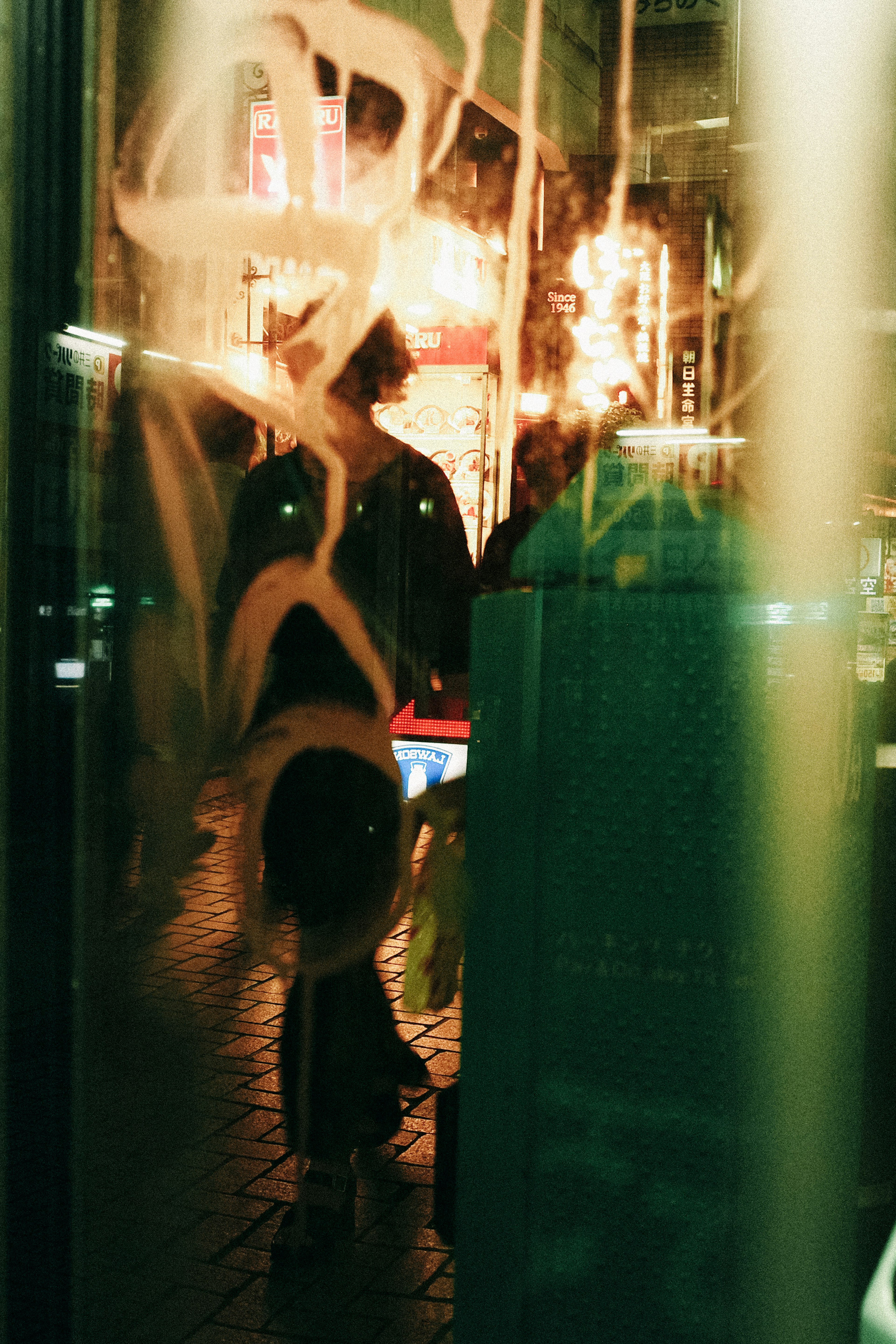 Figures reflected through a foggy window with colorful lights