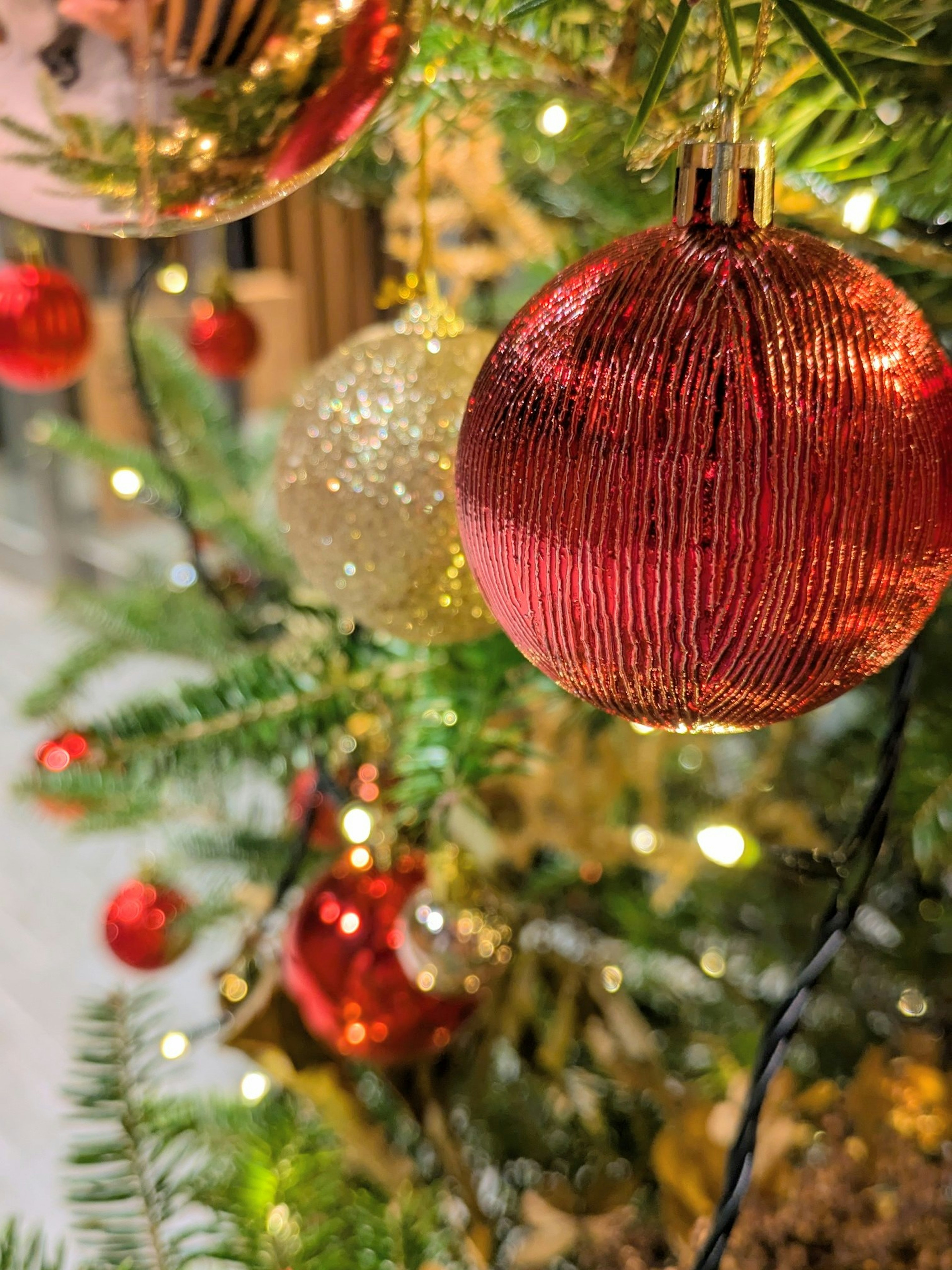 Close-up of red and gold ornaments on a Christmas tree