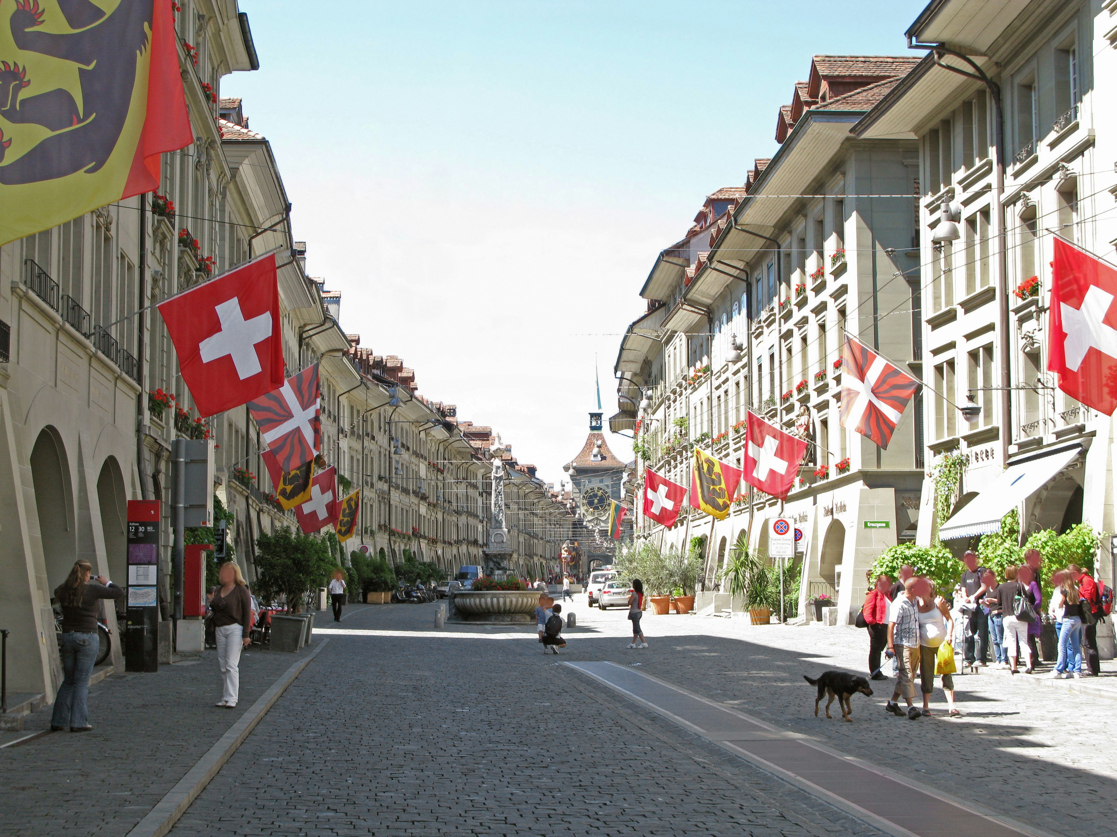 Vue de la rue de Berne avec des drapeaux suisses et une route en pavés