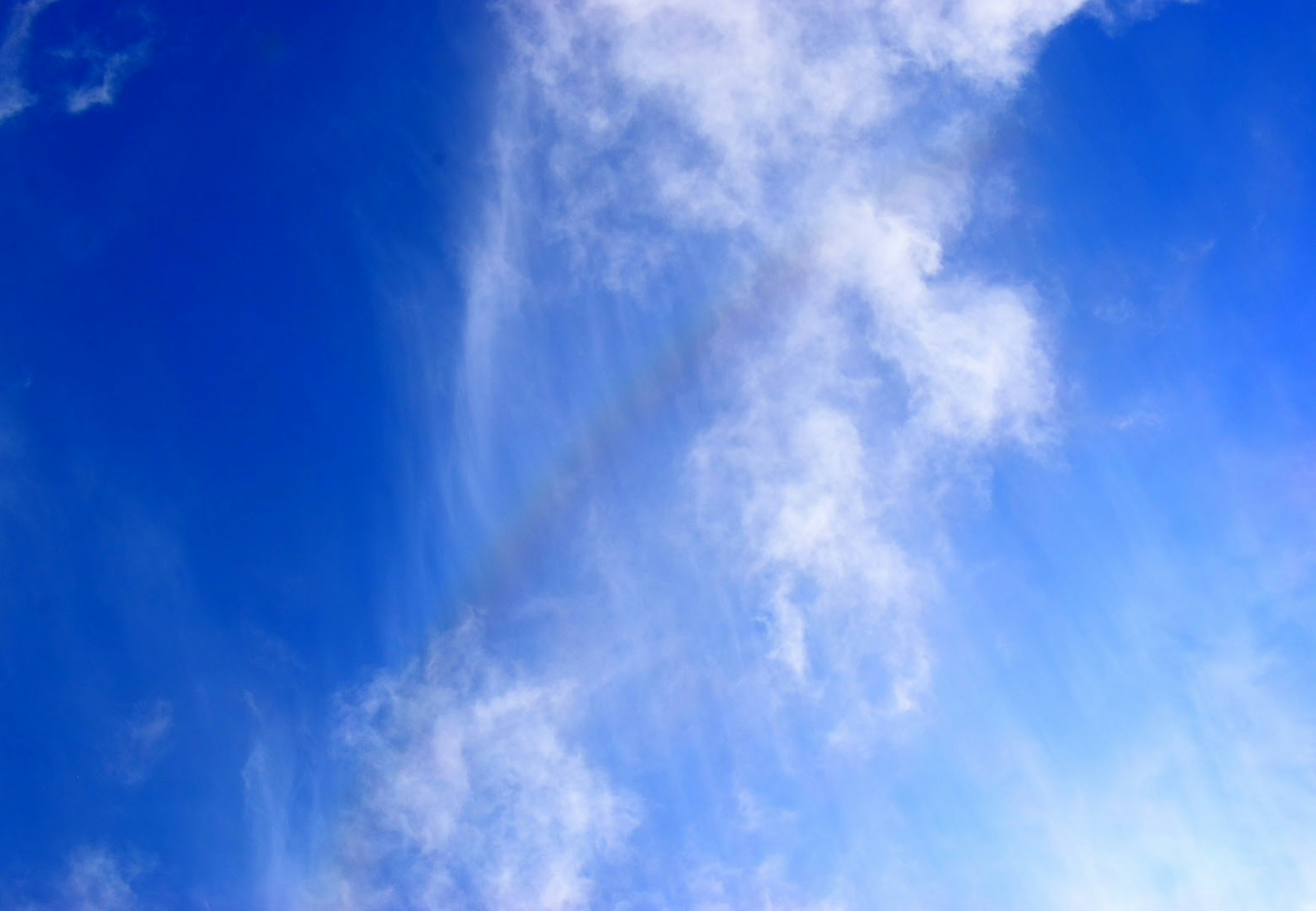 Awan tipis menyebar di langit biru yang cerah