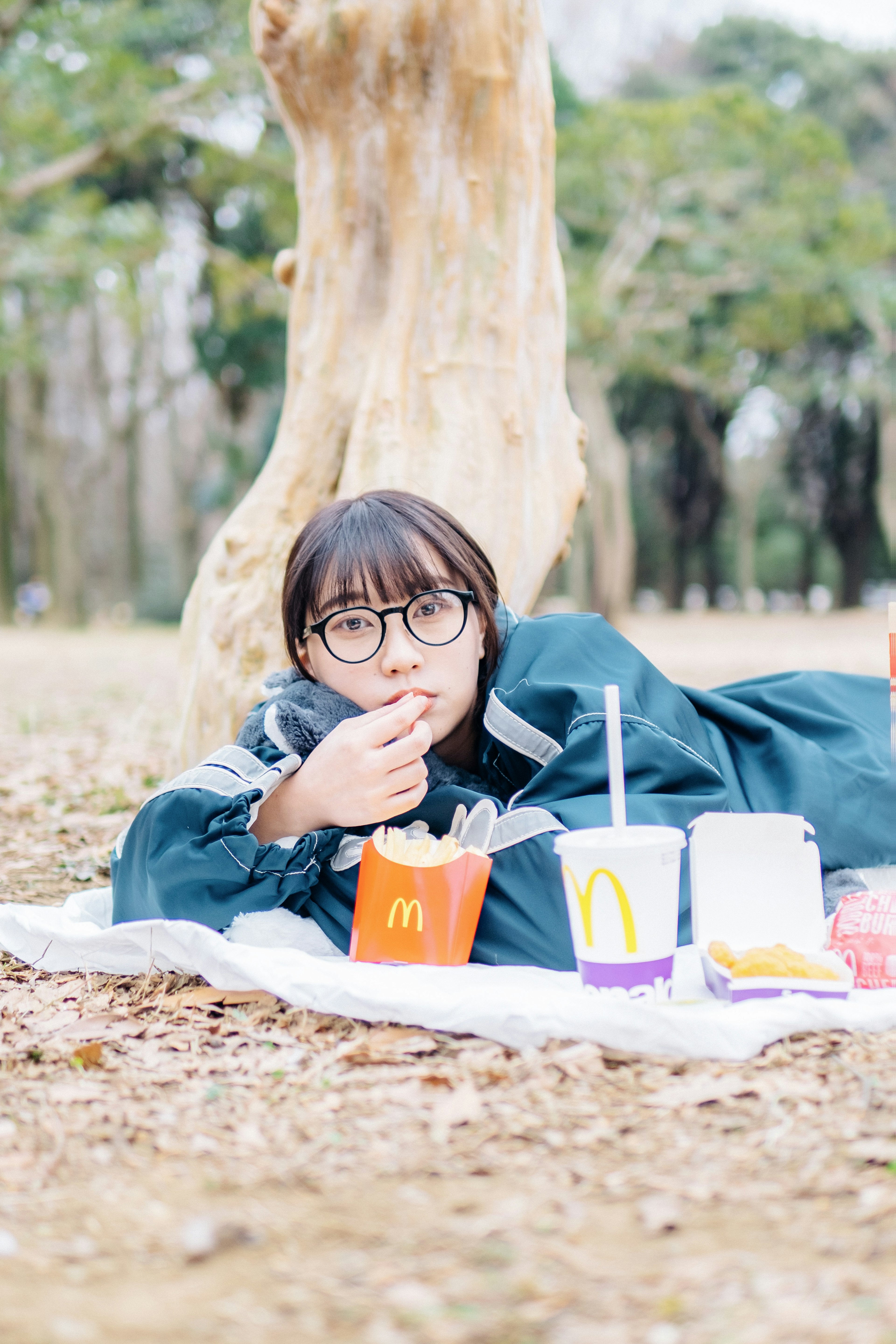 公園でマクドナルドの食事を楽しむ女性の写真