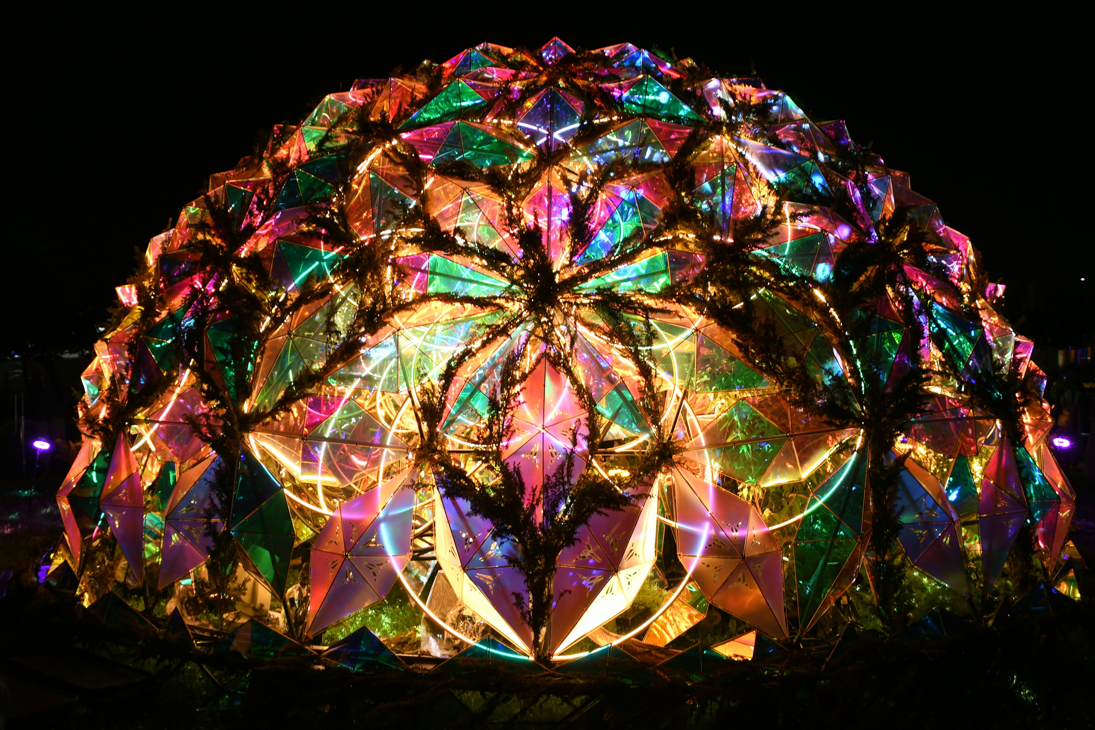 Colorful dome-shaped art installation glowing at night