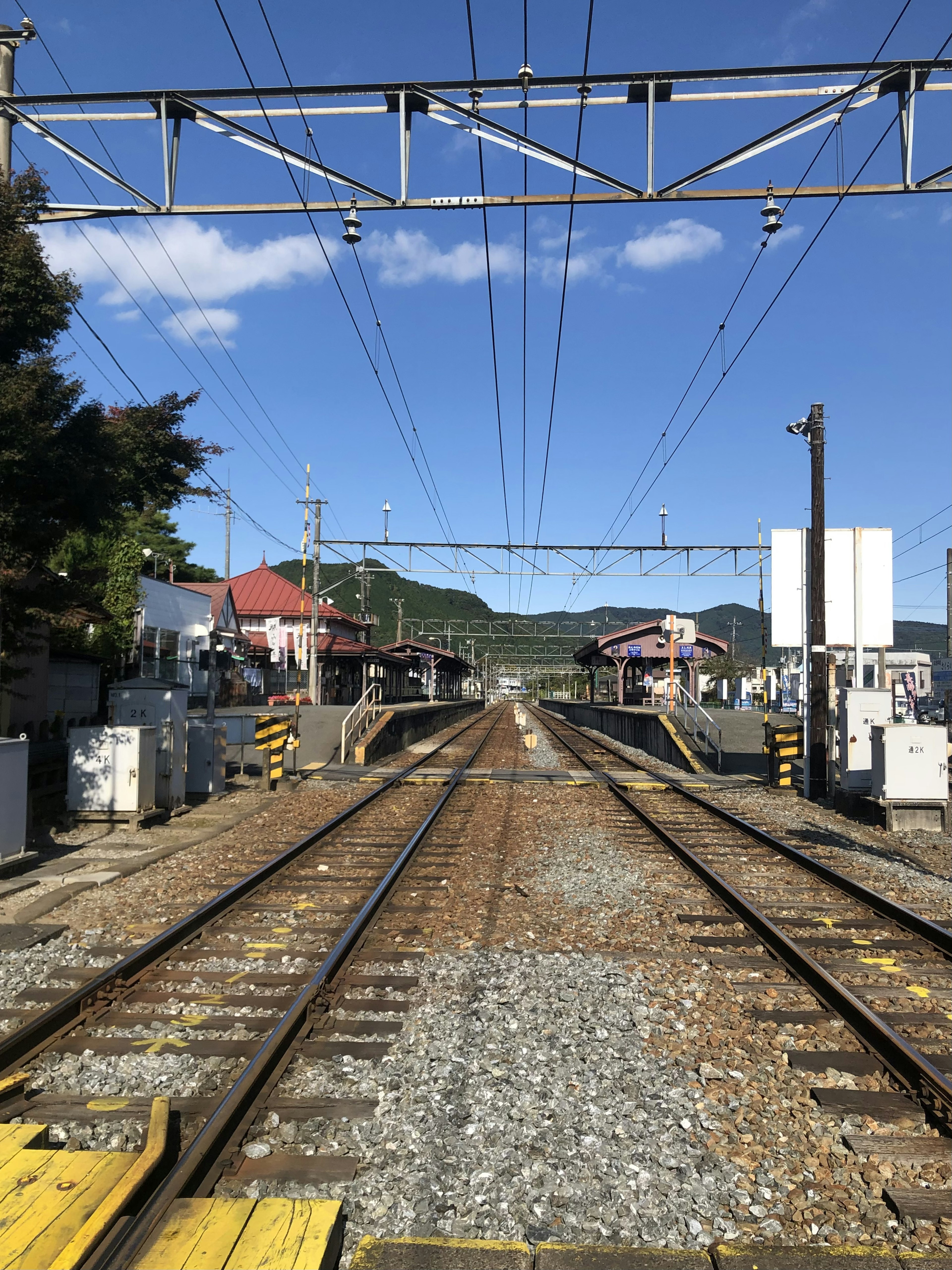 철도 선로와 주변 풍경을 보여주는 이미지 파란 하늘과 구름