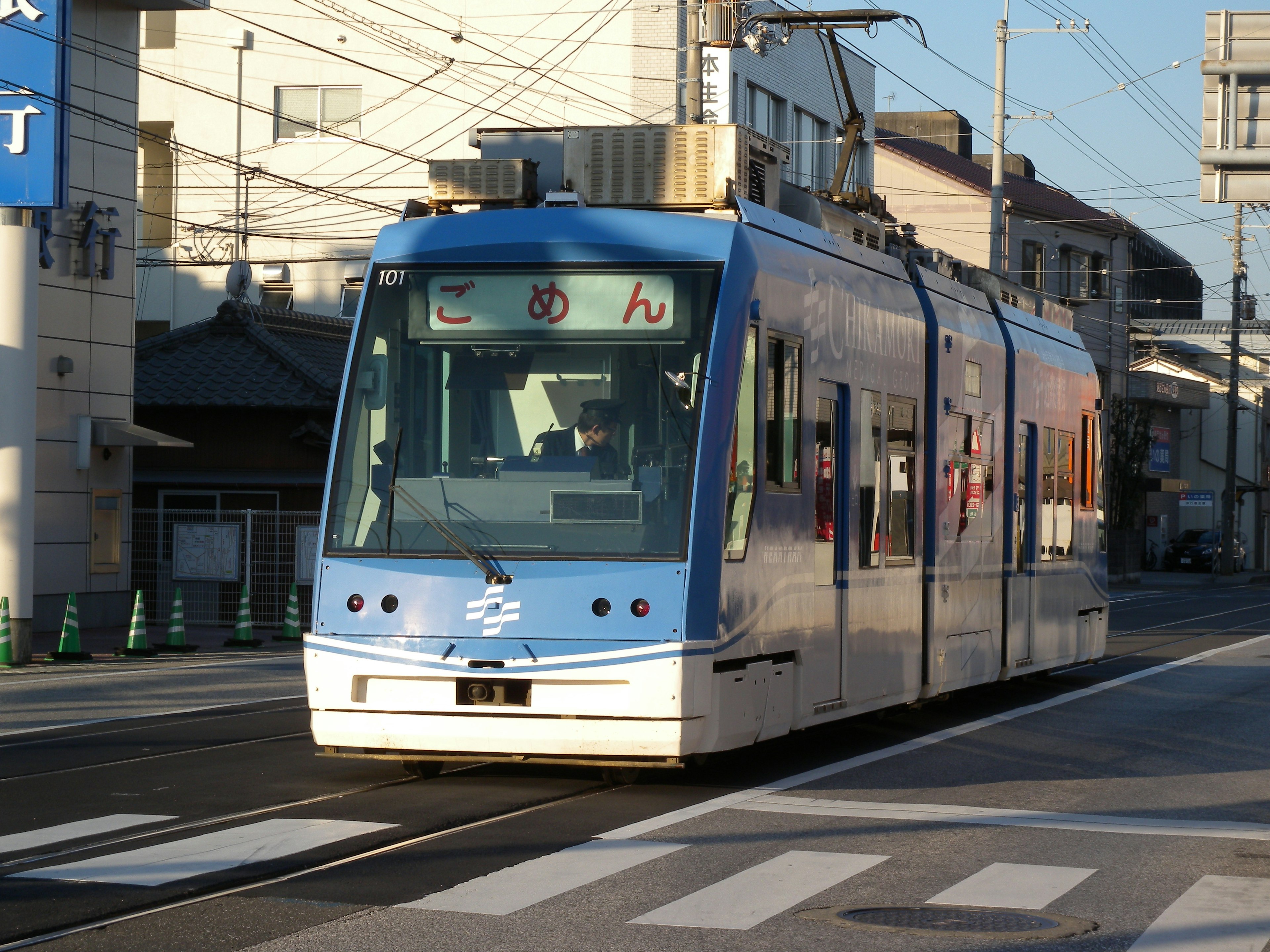 Blue streetcar traveling through a city street