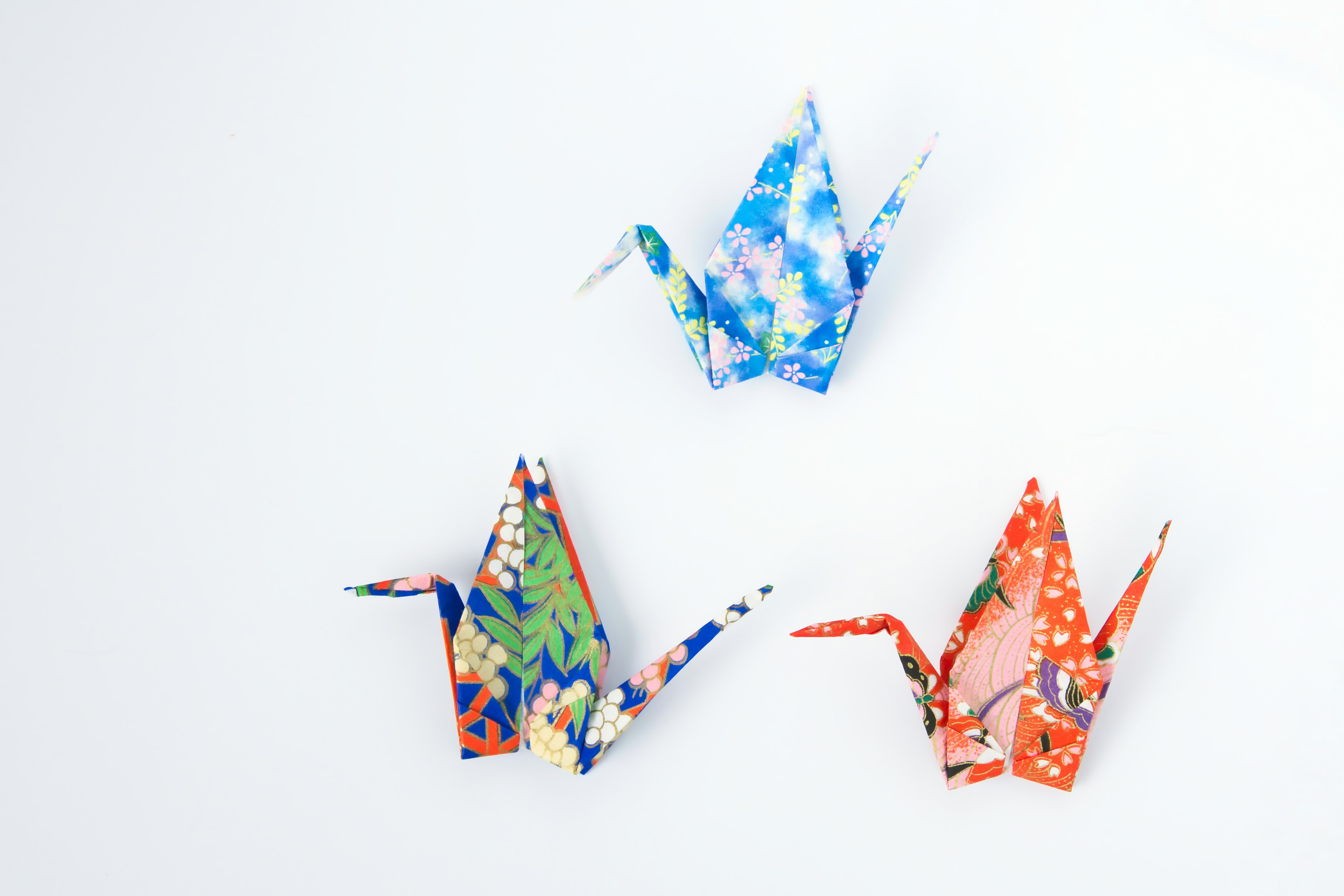 Colorful origami cranes displayed on a white background