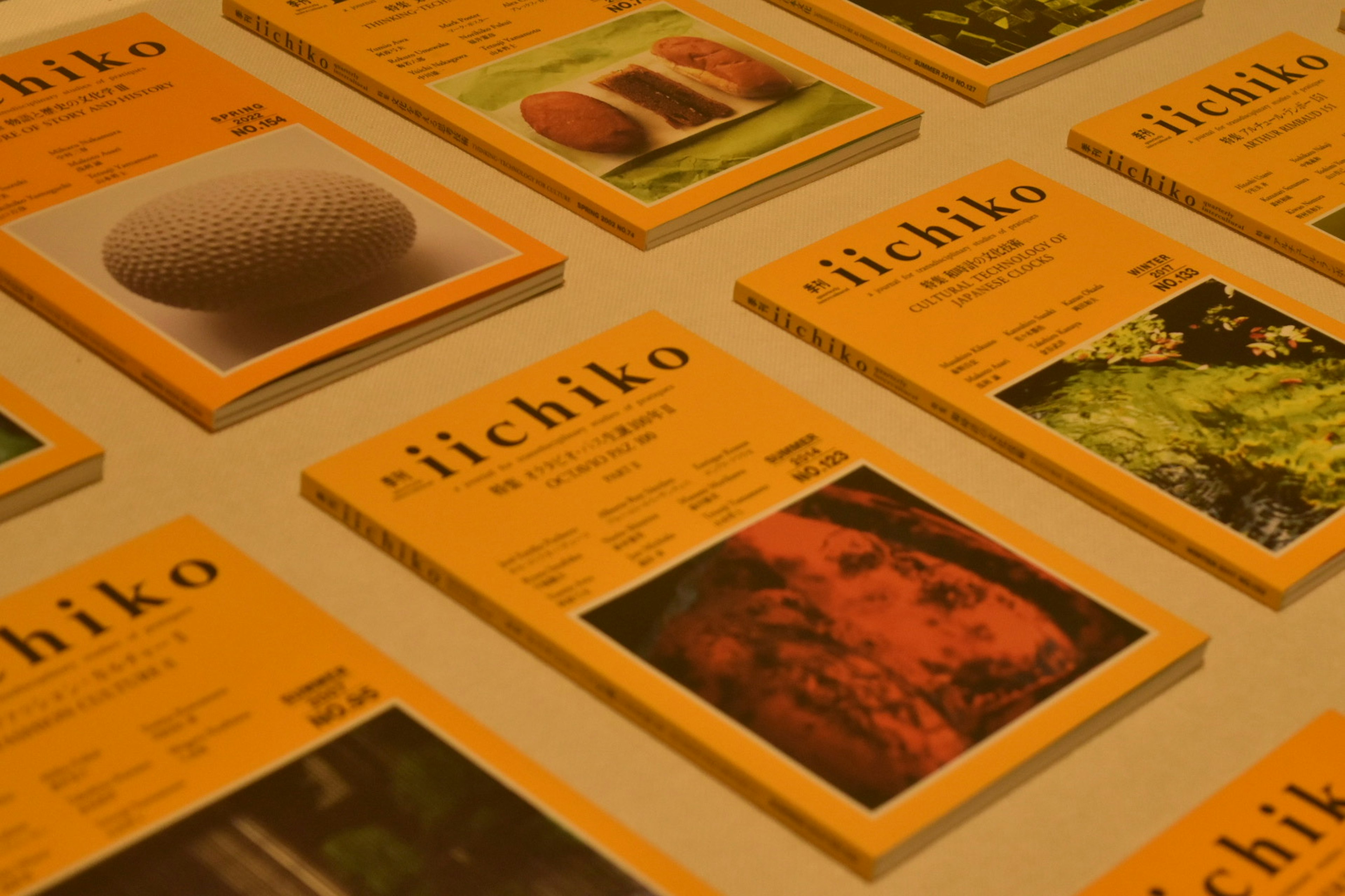 A layout of Ichiko magazine covers featuring vibrant orange designs