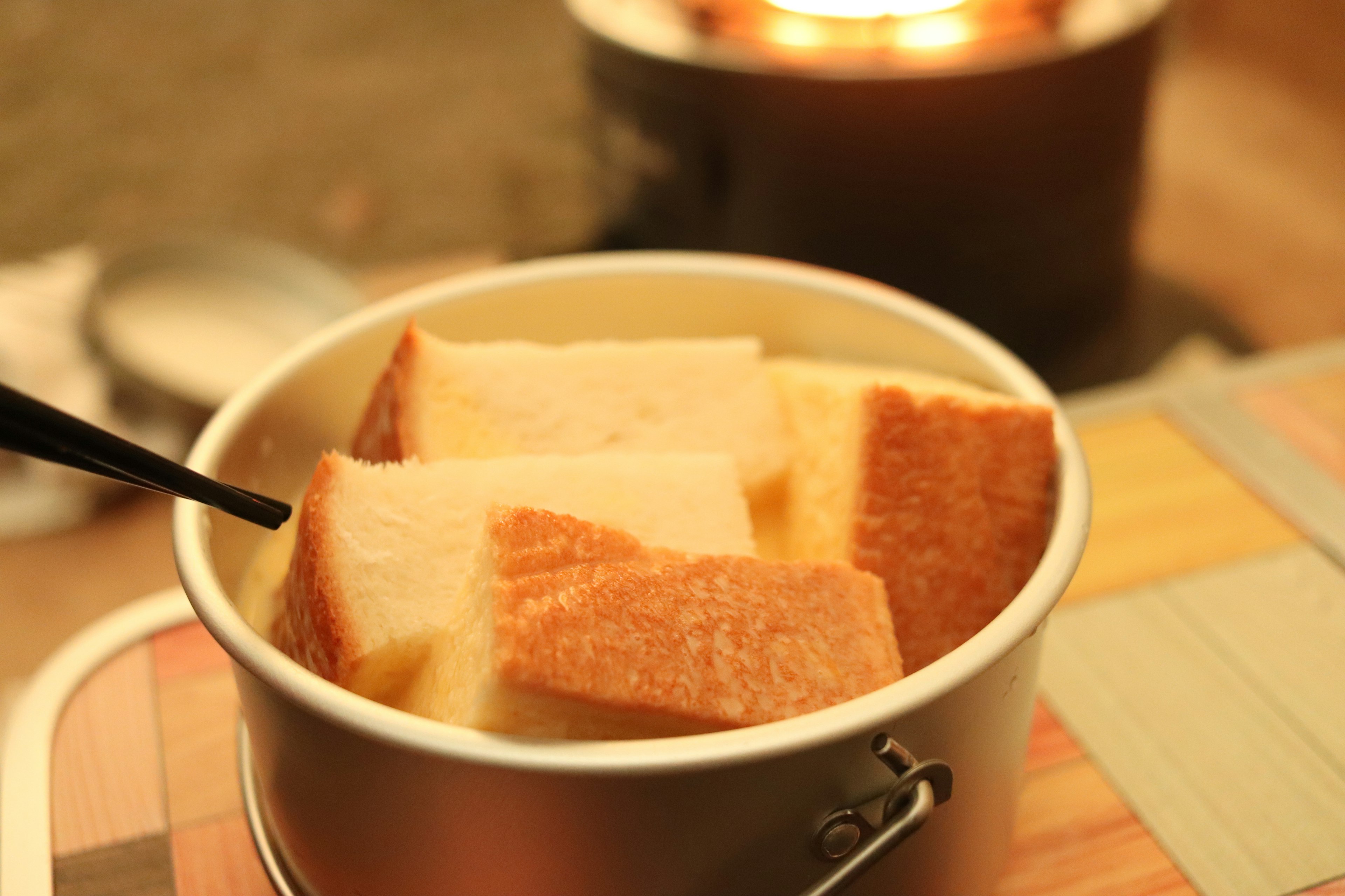 A pot filled with soft bread pieces on a wooden table