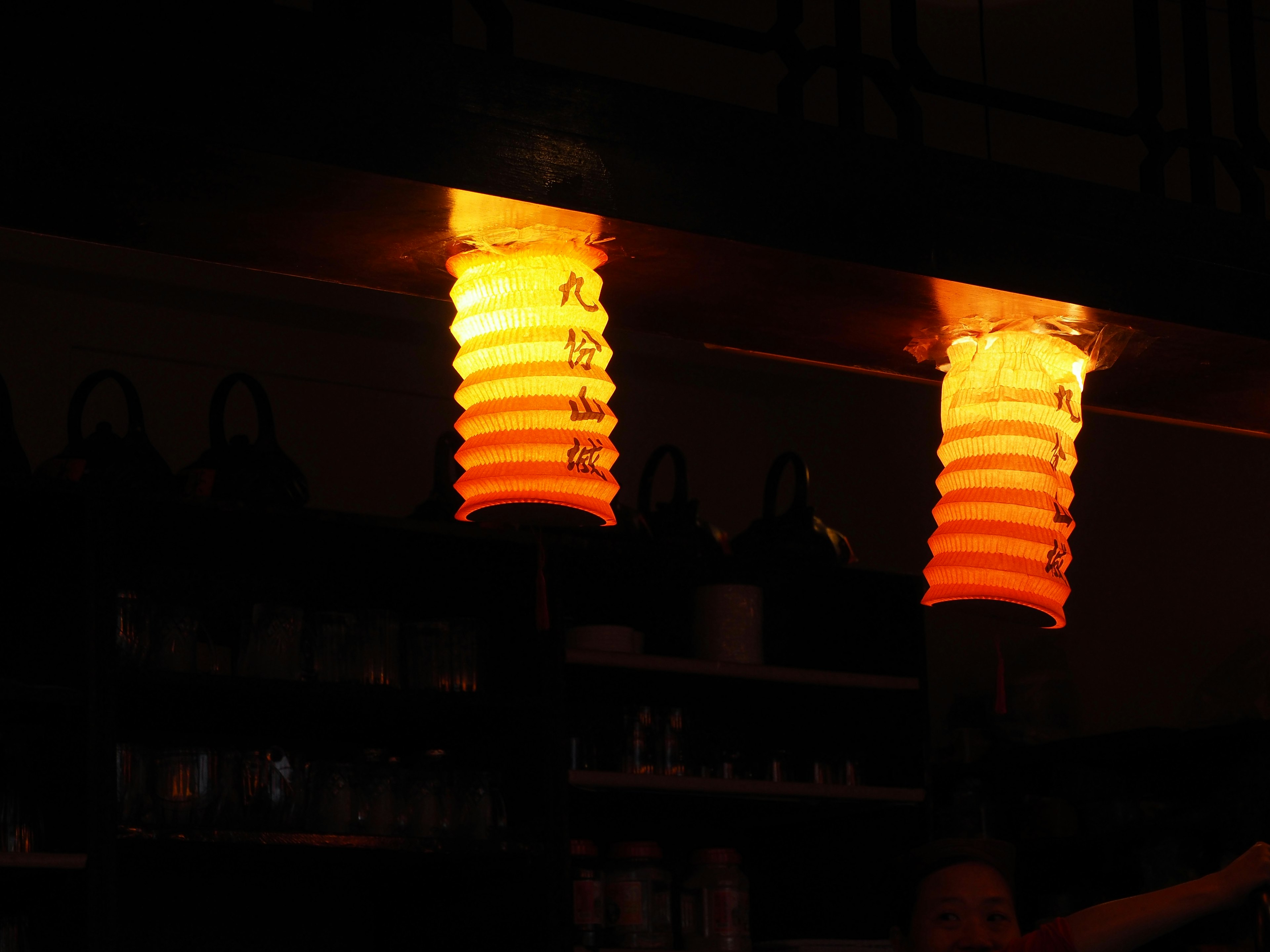 A scene of dimly lit room with orange lanterns casting warm light