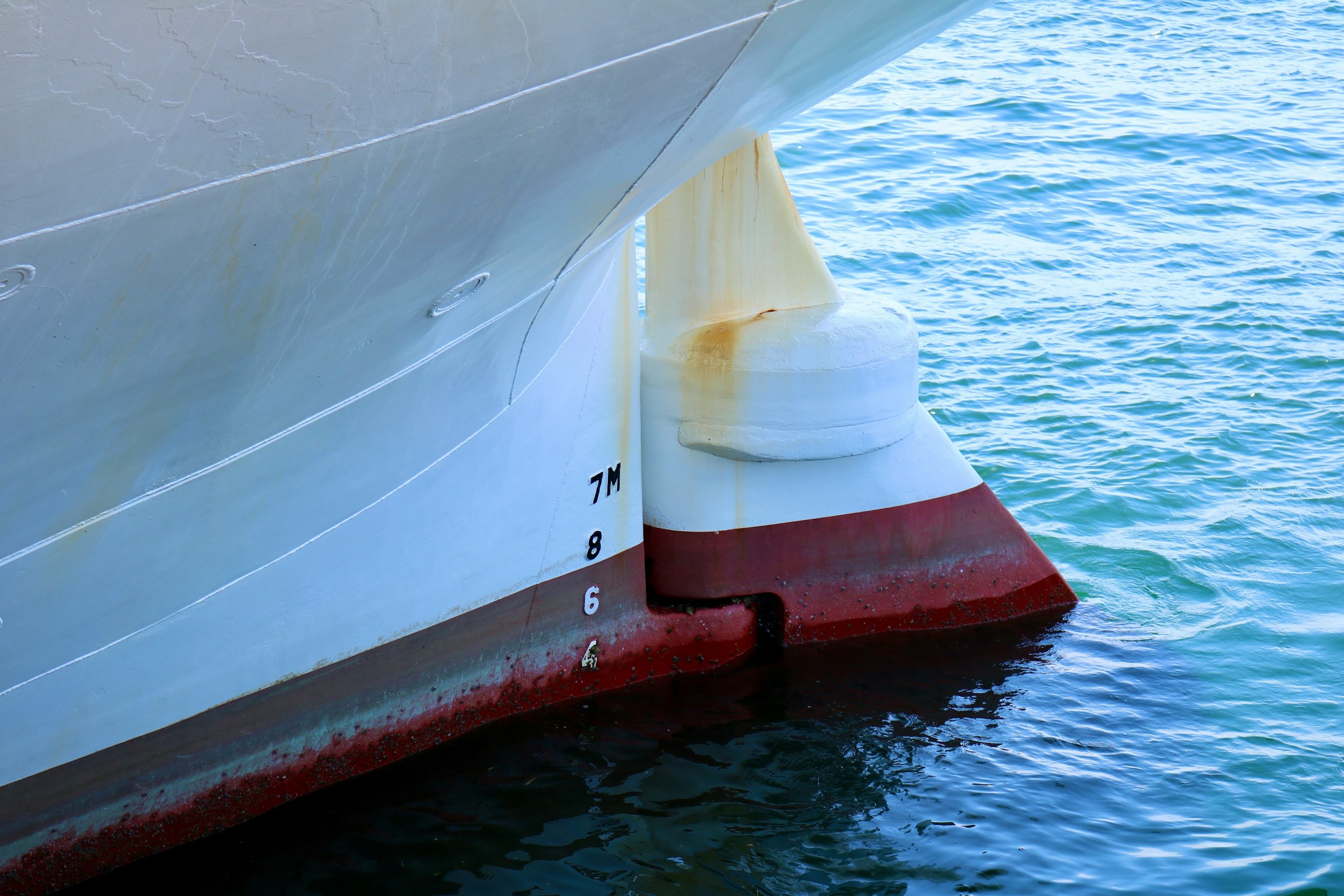 Immagine che mostra lo scafo di una nave con uno schema di colori bianco e rosso all'altezza della linea di galleggiamento