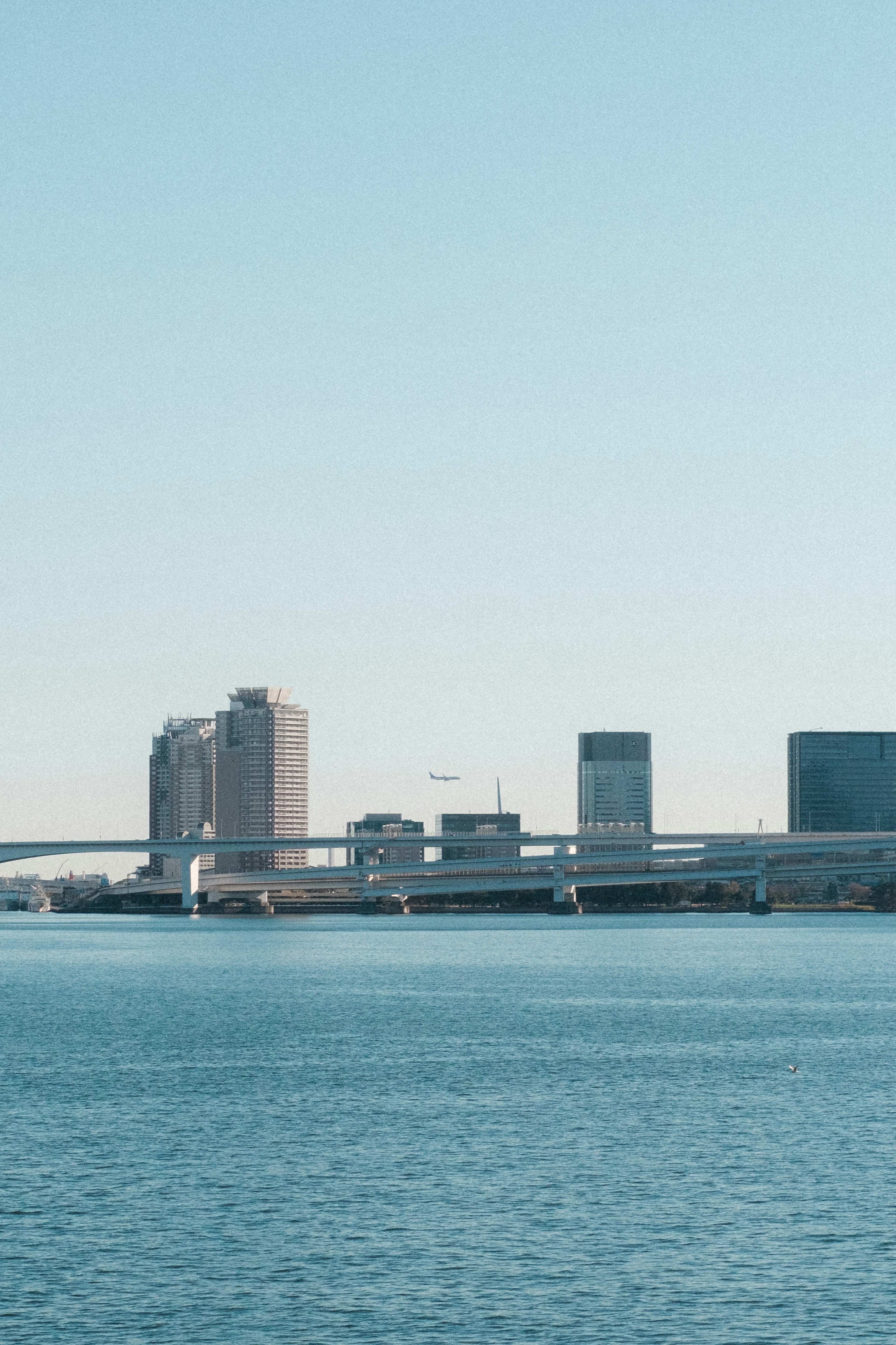 Horizon urbain avec des gratte-ciel et de l'eau bleue calme