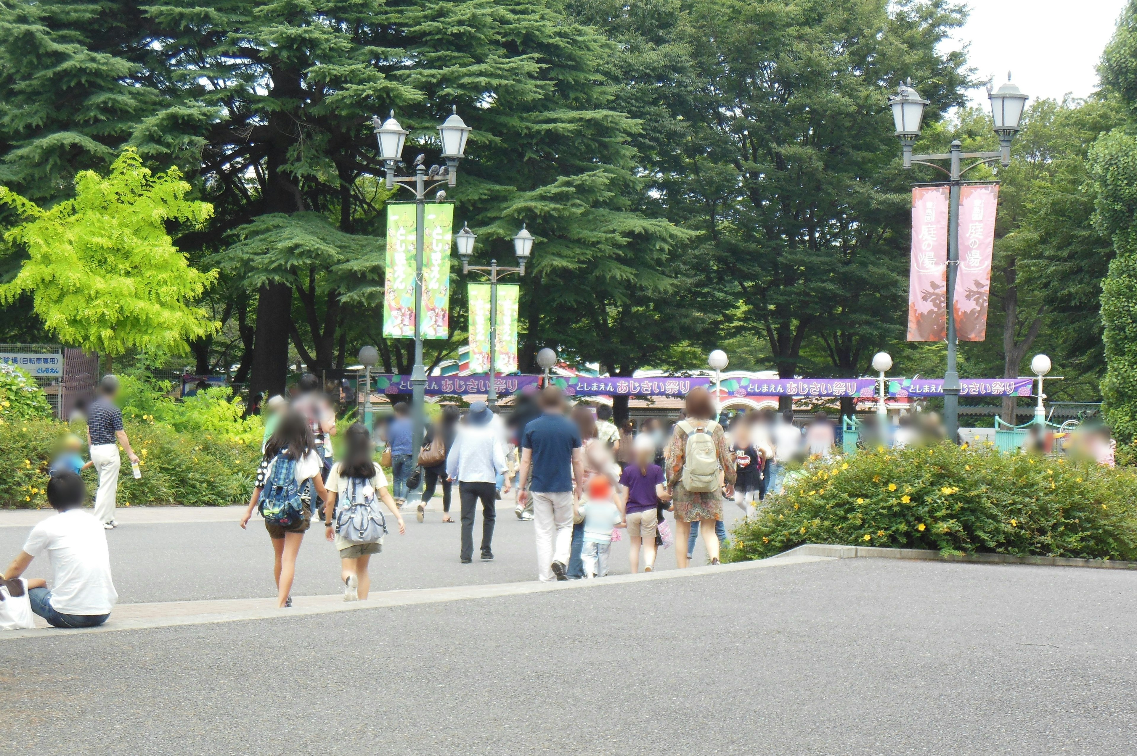 緑豊かな公園で人々が歩いている様子いくつかのバナーが立っている