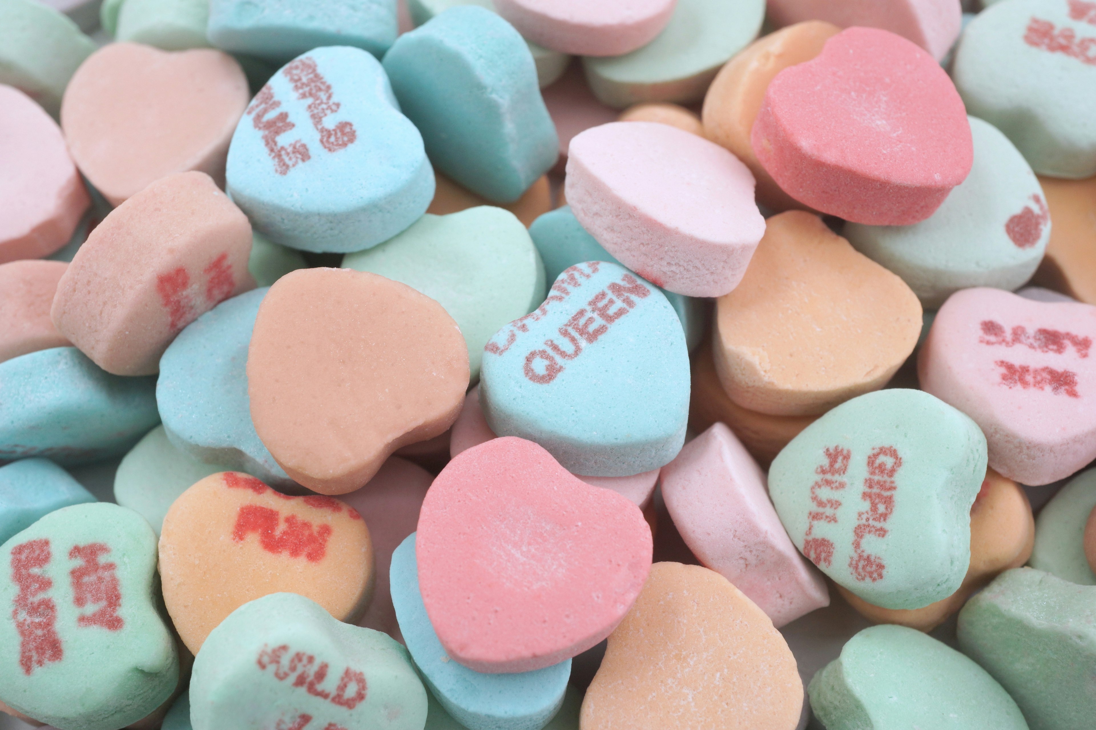 Colorful heart-shaped candies scattered with playful messages