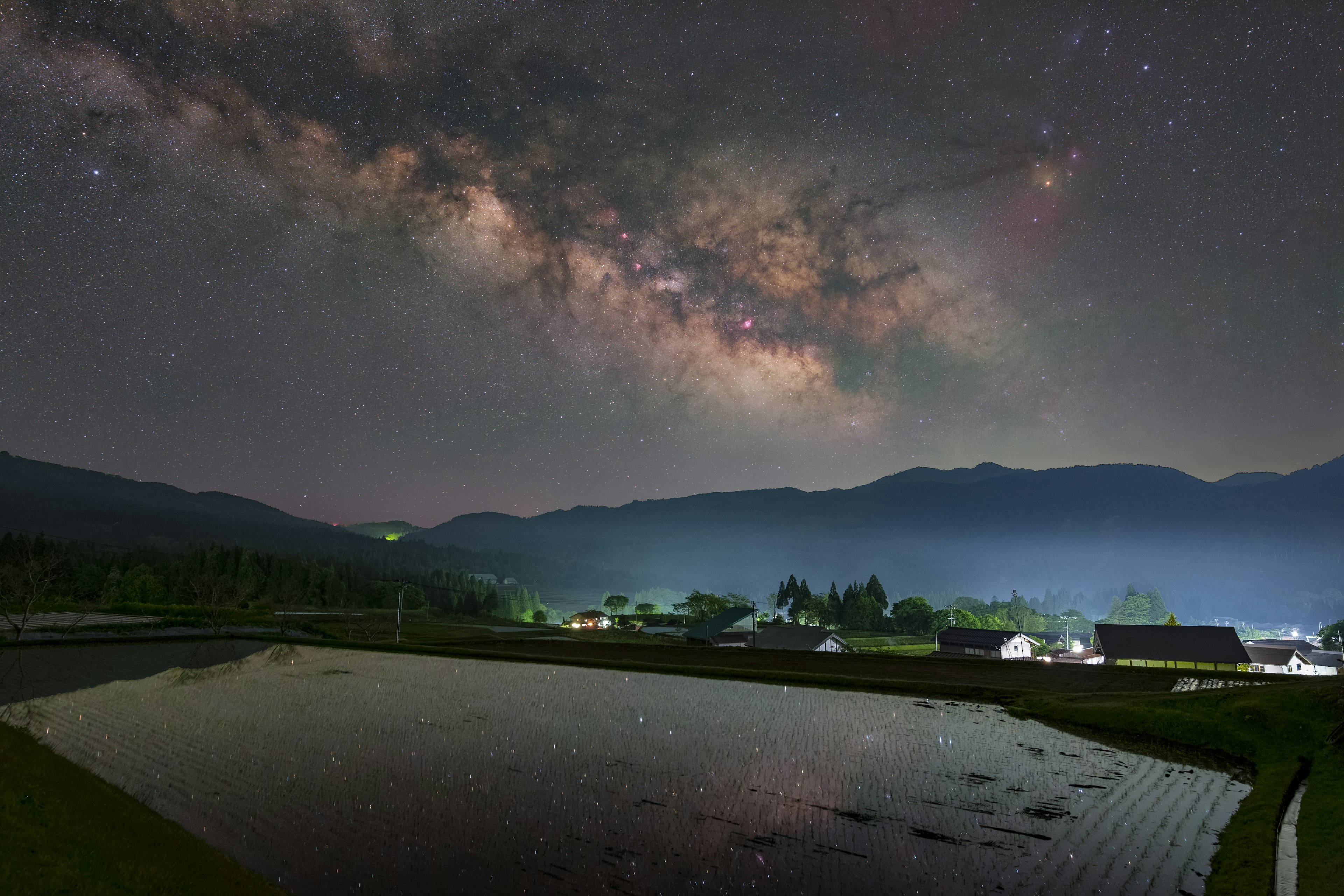 美しい星空とミルキーウェイが広がる田園風景の夜景