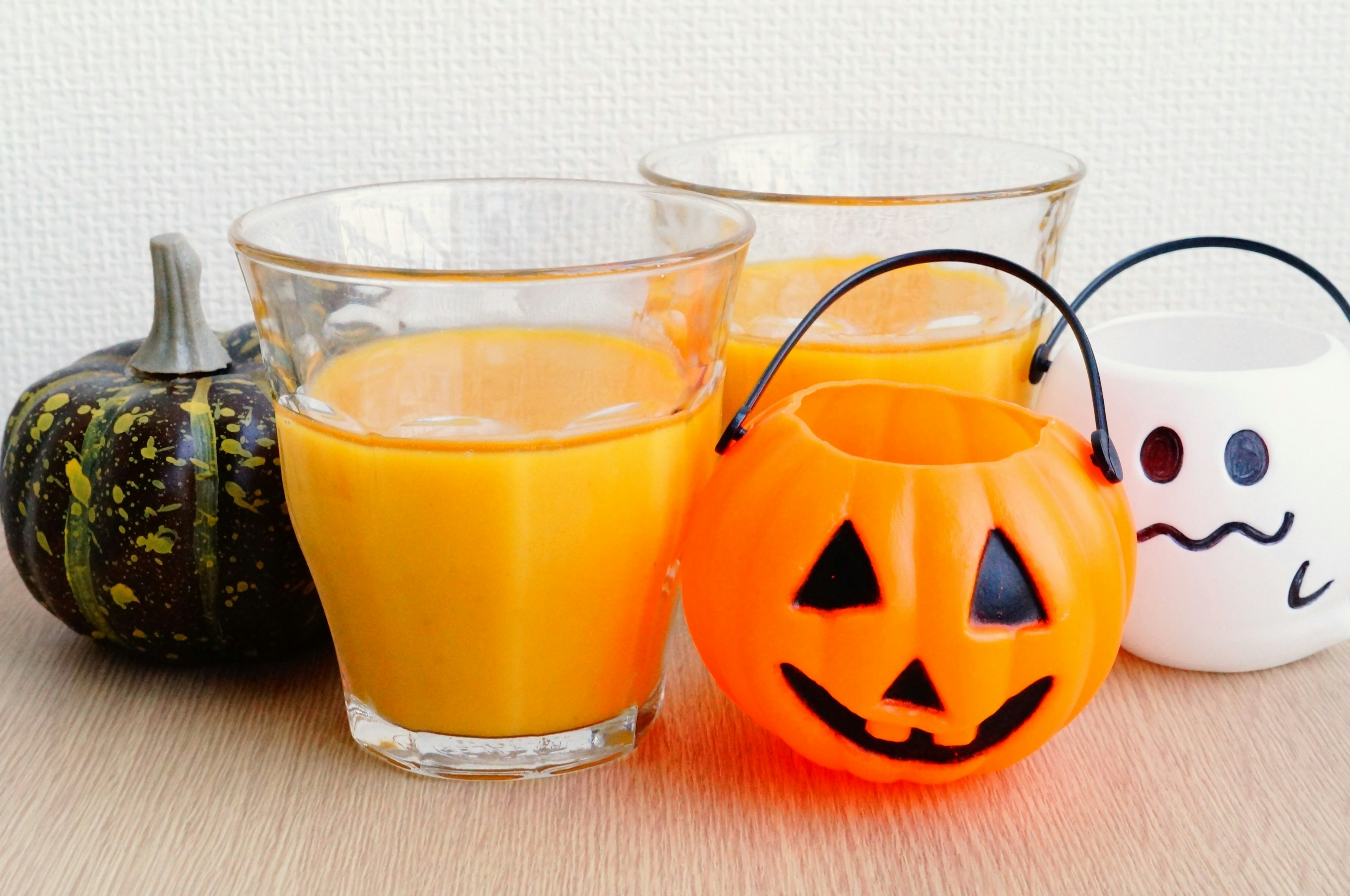 Bild mit Orangensaft und einem Halloween-Kürbis-Süßigkeitenbehälter