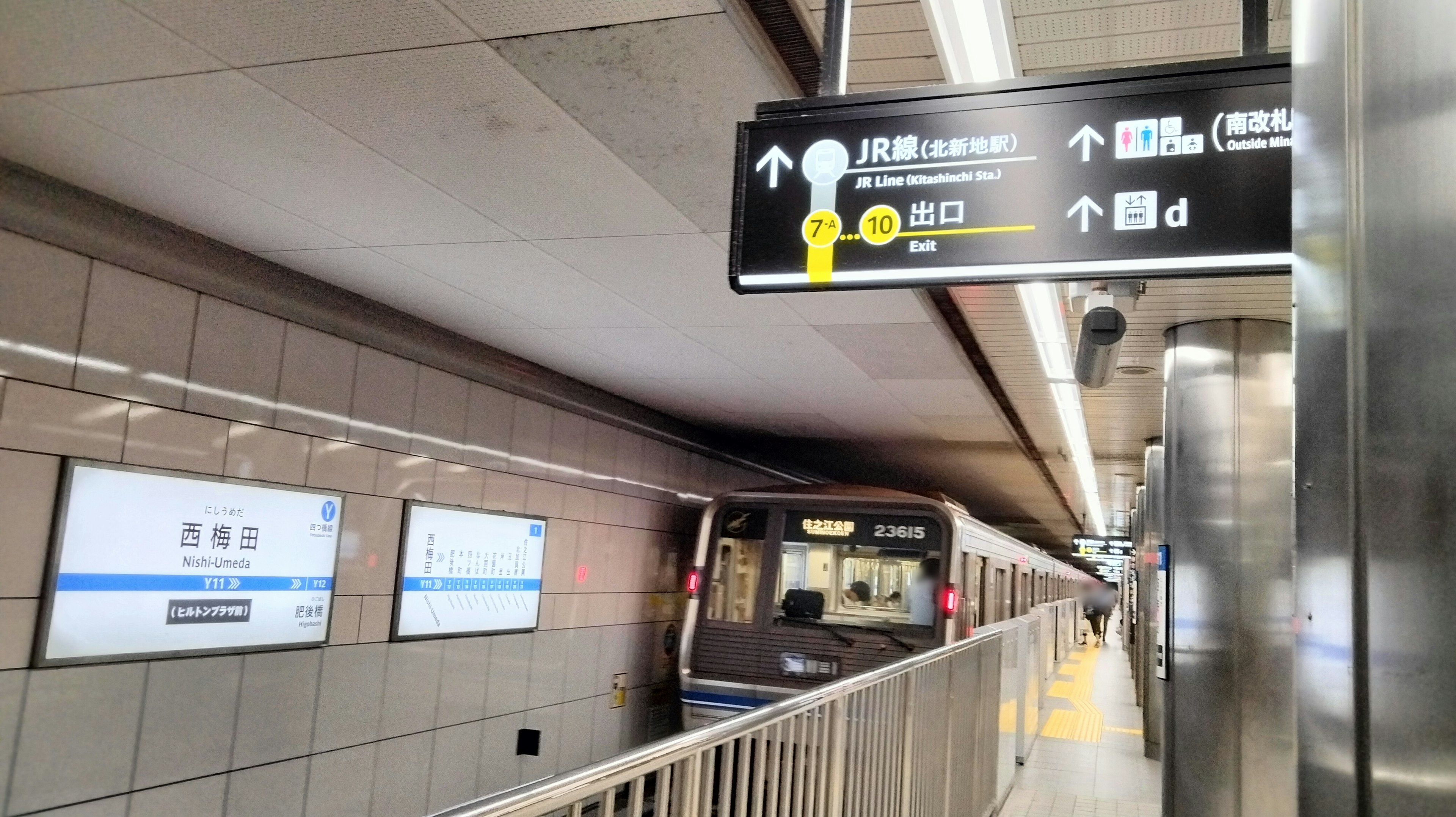 Subway station platform with a train and directional signage