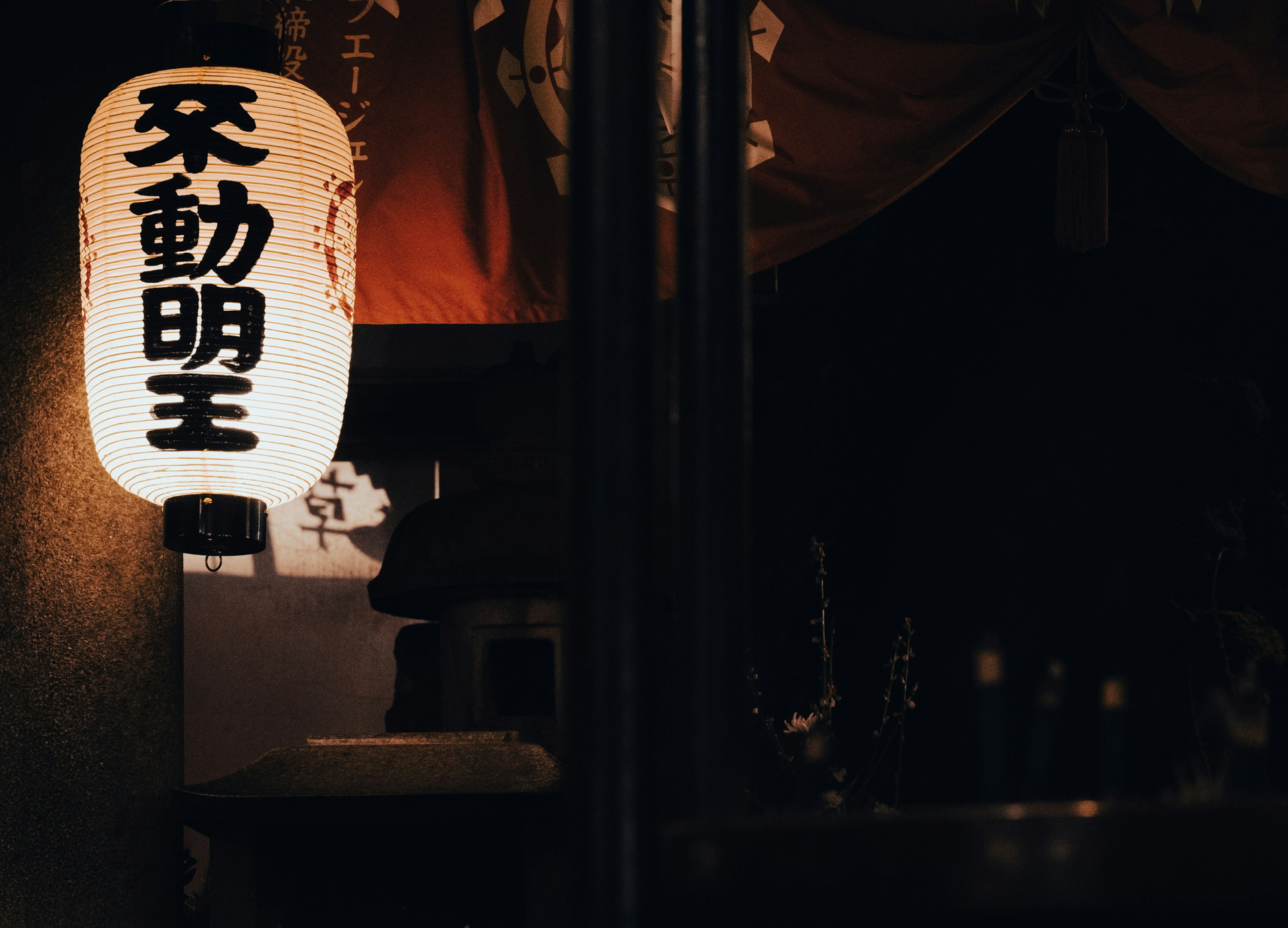 Japanese lantern glowing in the dark with black characters on a white background