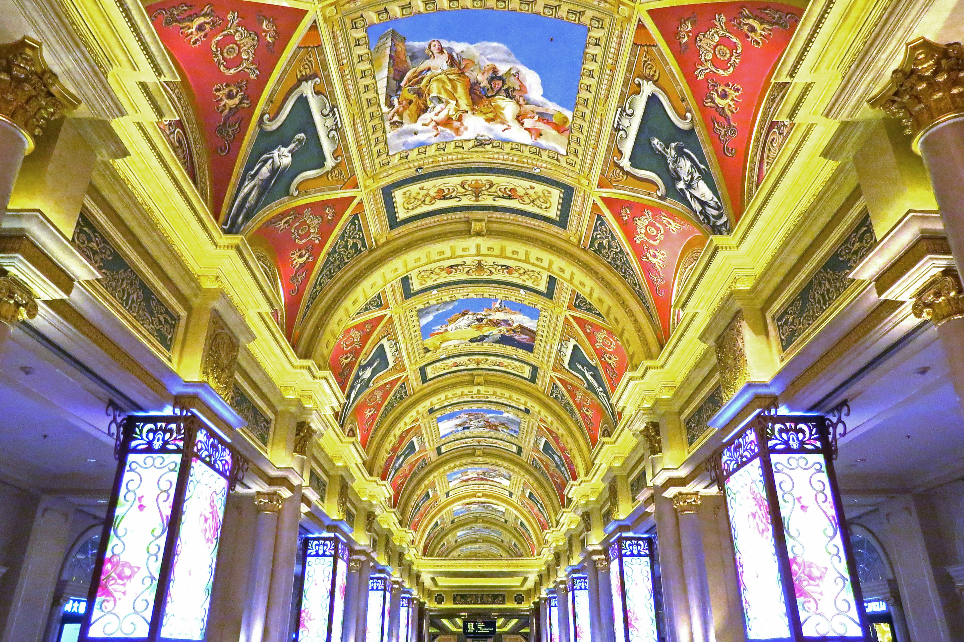 Interior de un edificio con arte en el techo y decoraciones doradas