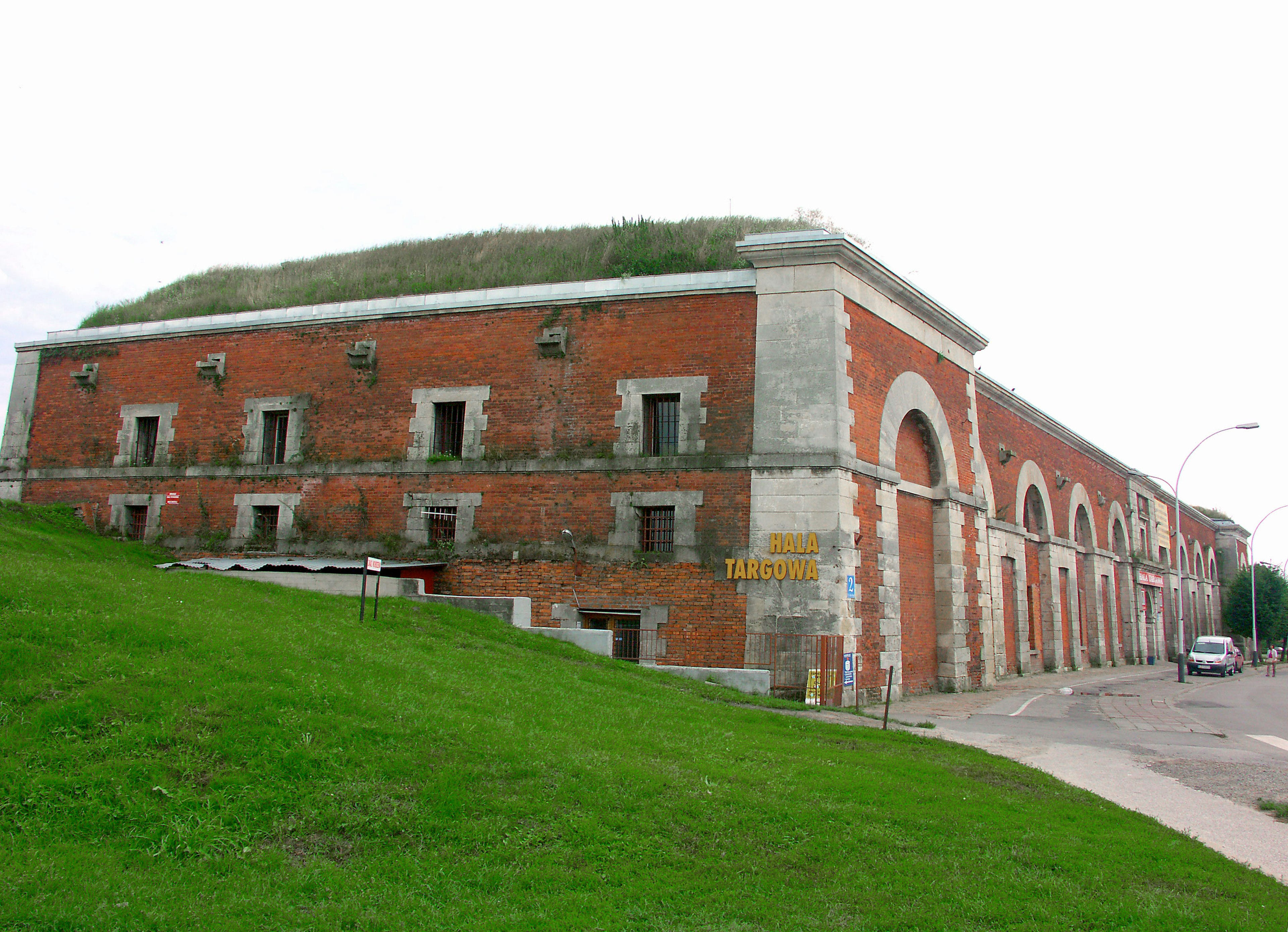 Vista laterale di un edificio in mattoni rossi con un tetto erboso