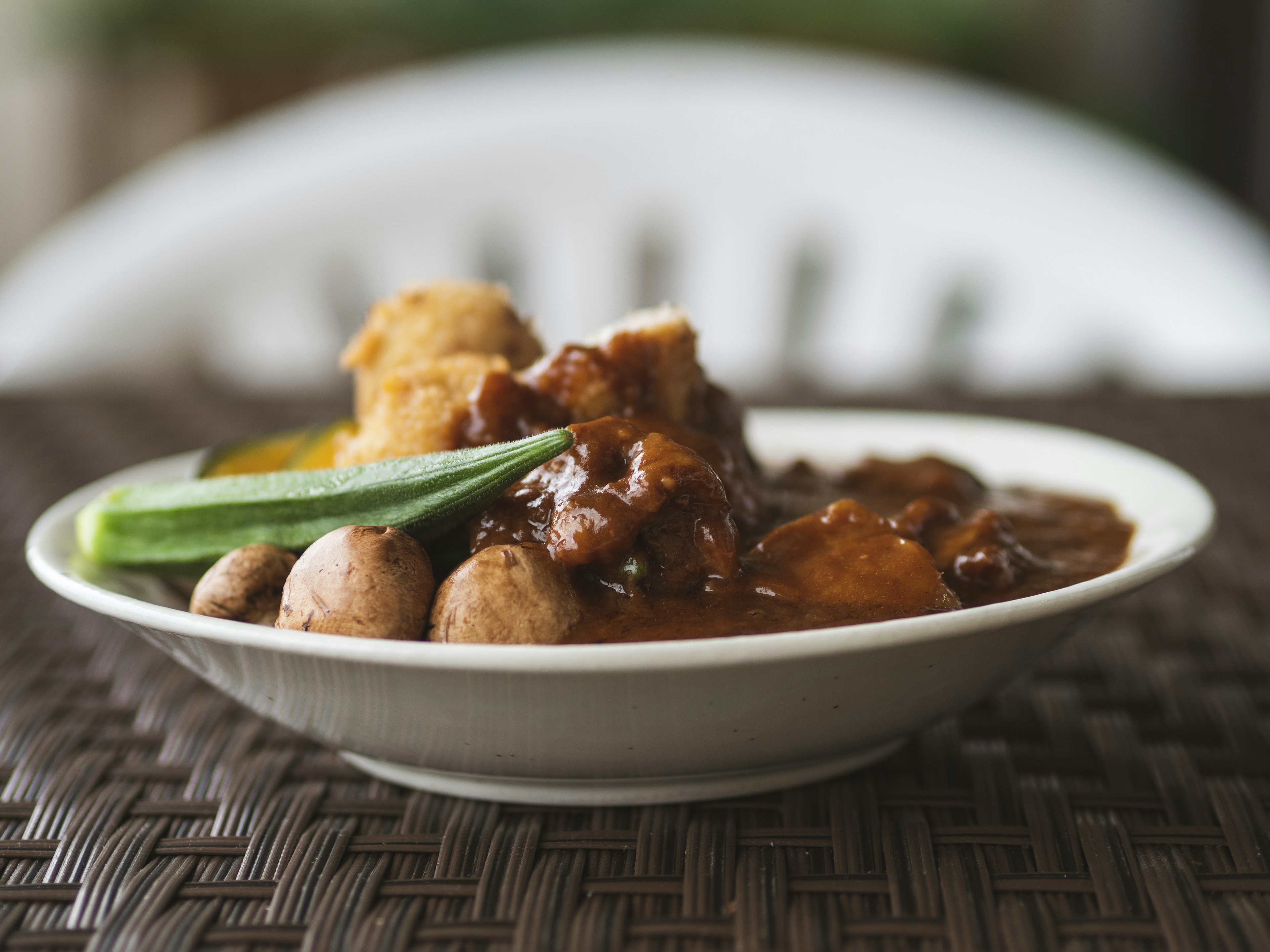 Une assiette de poulet dans une sauce avec concombre et champignons à côté