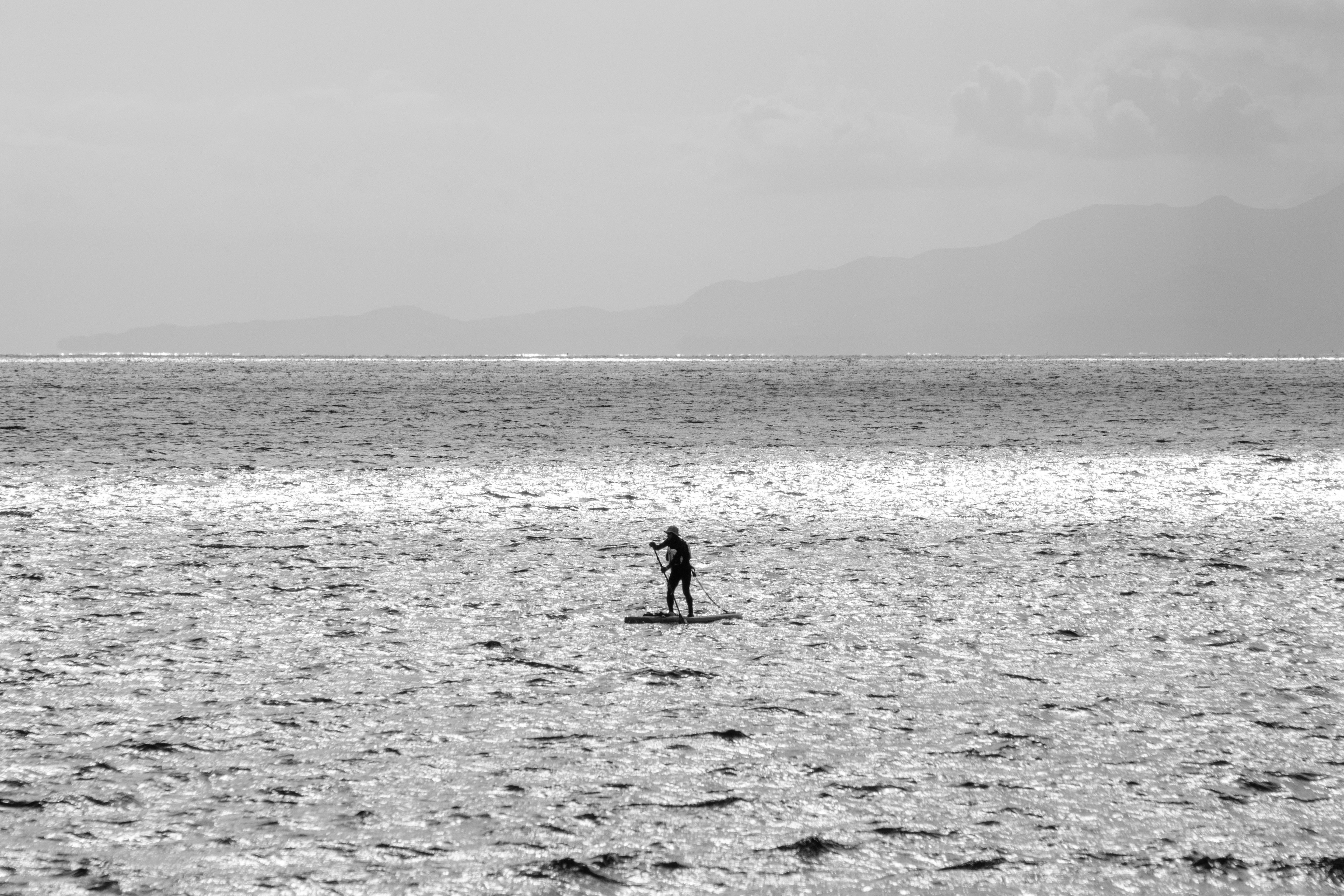 Black and white photo of a person surfing on the ocean