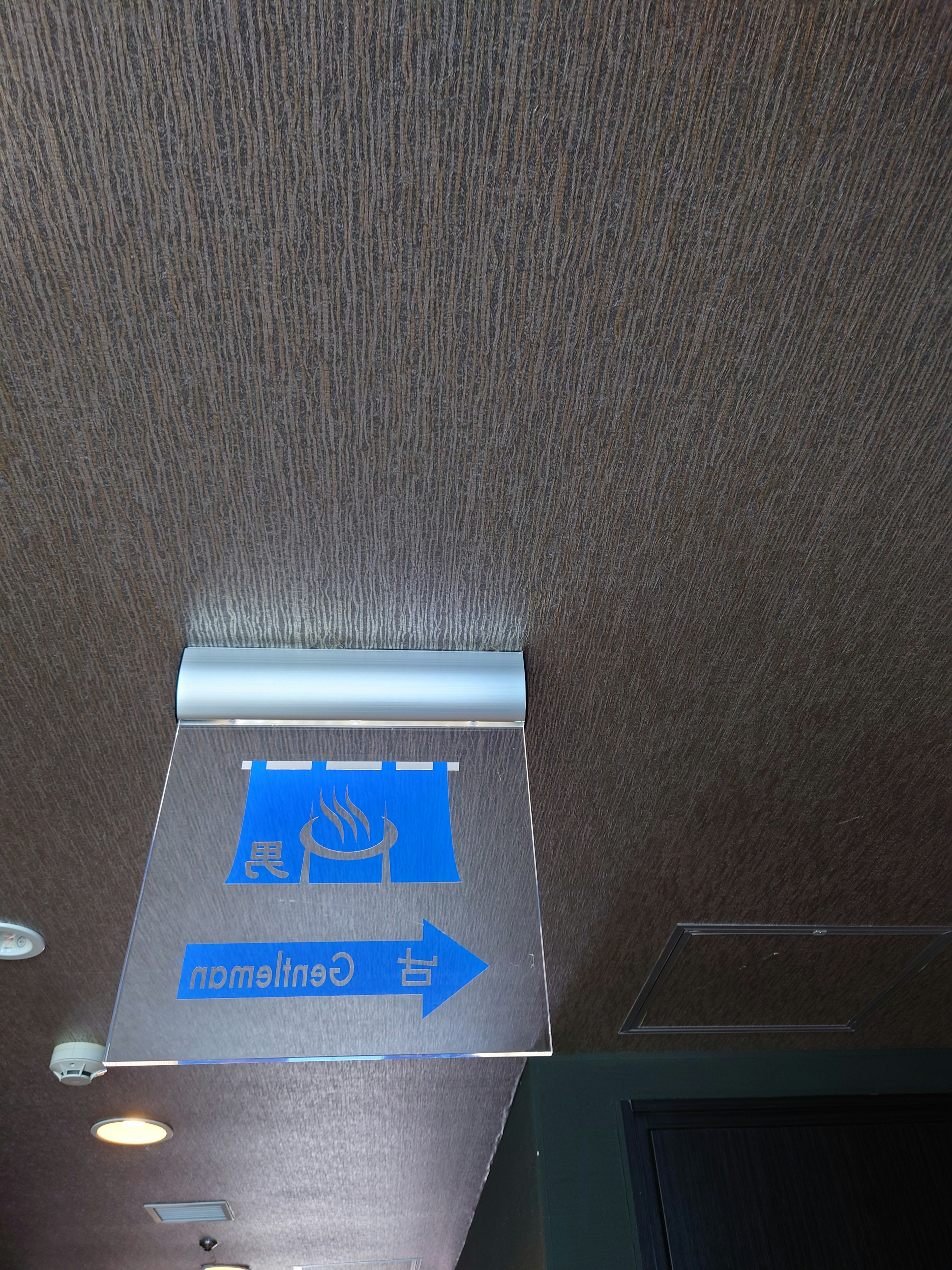 Blue directional sign mounted on the ceiling