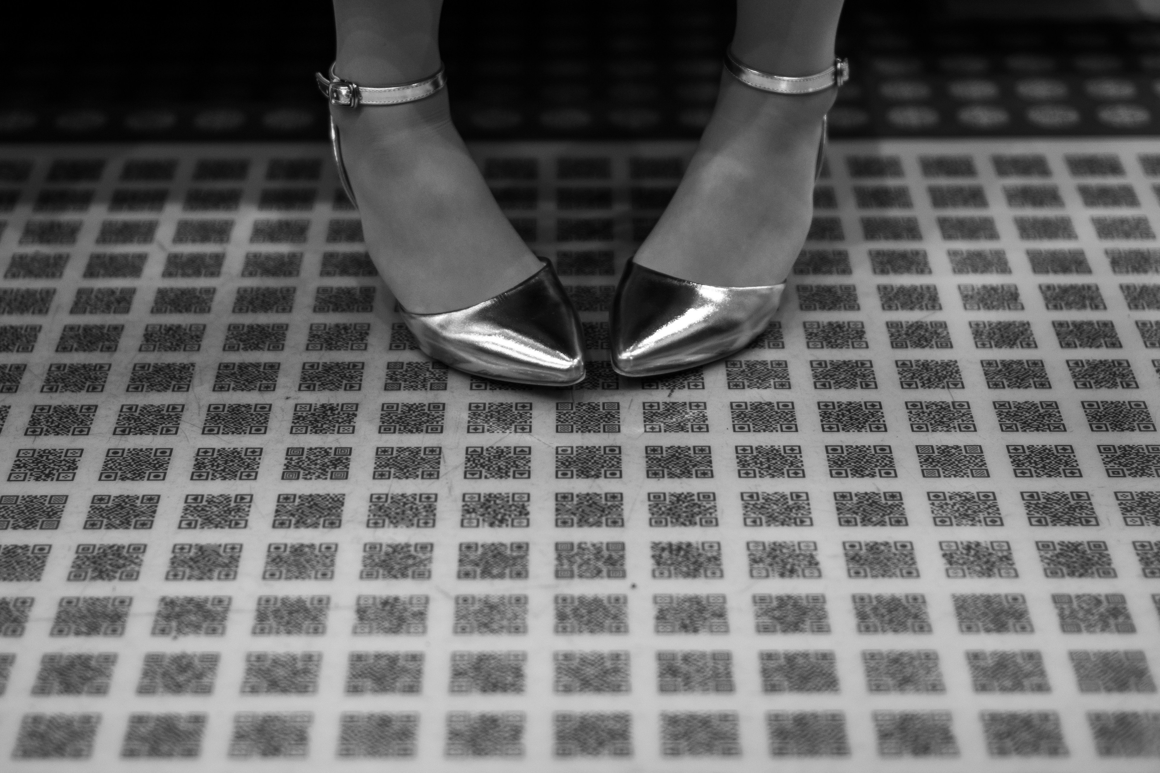 Black and silver high heels placed on tiled floor