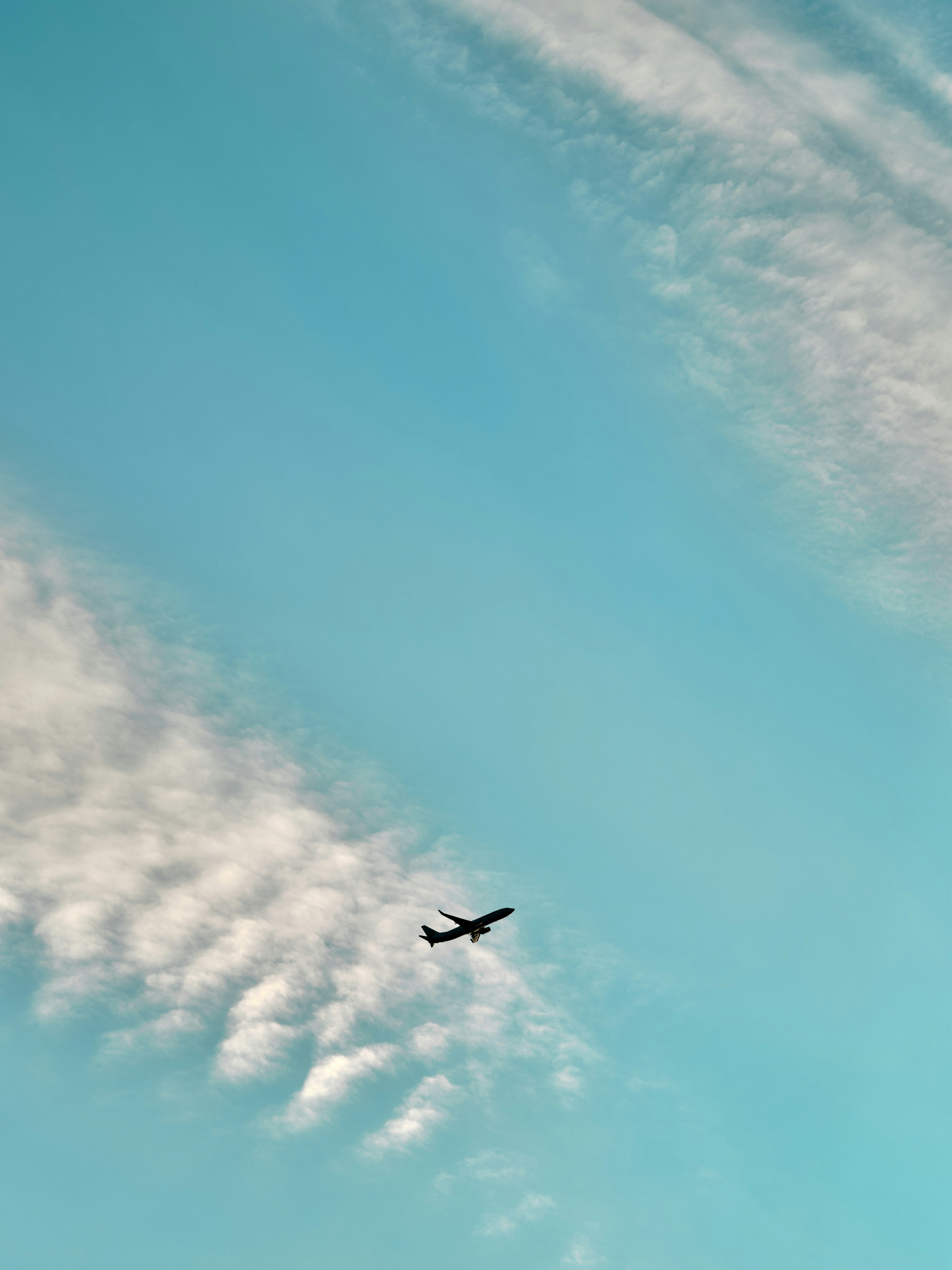 Pesawat terbang di langit biru dengan pola awan