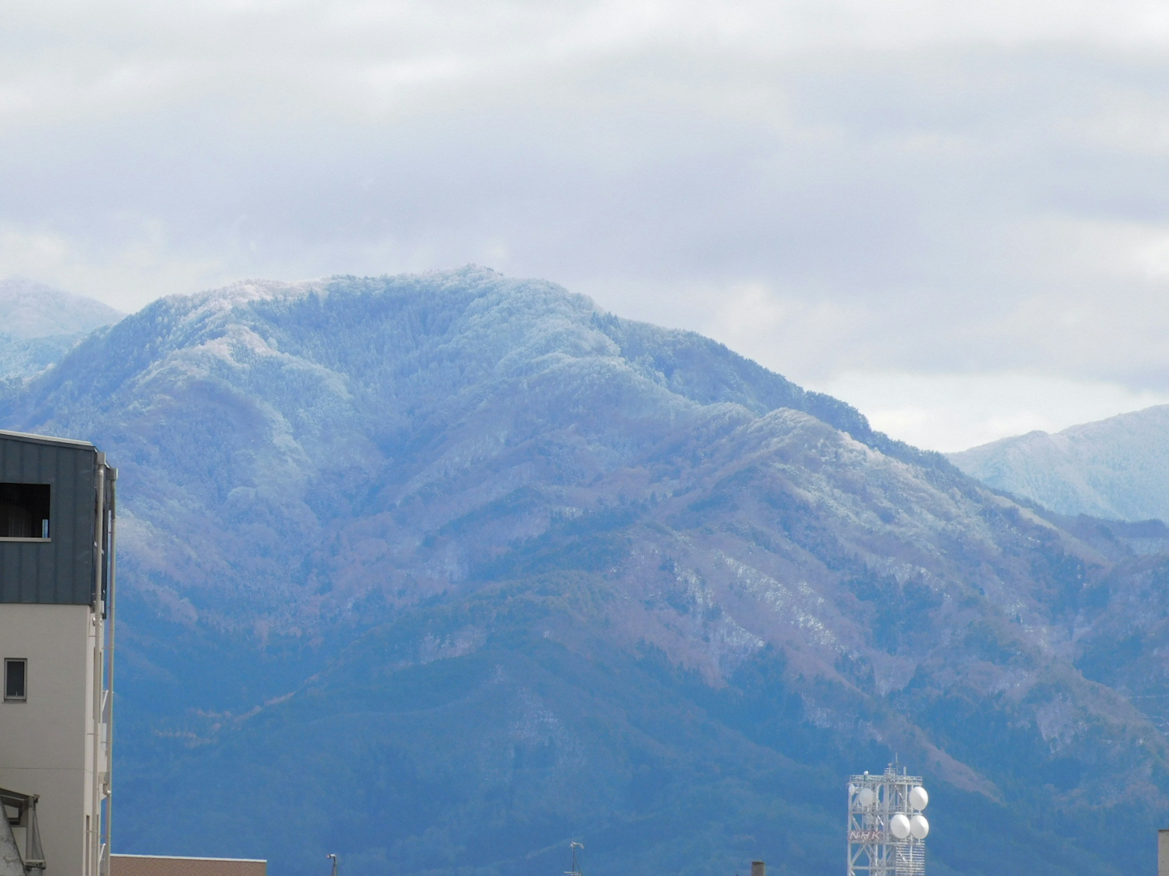 Vue panoramique d'une montagne bleue sous un ciel nuageux