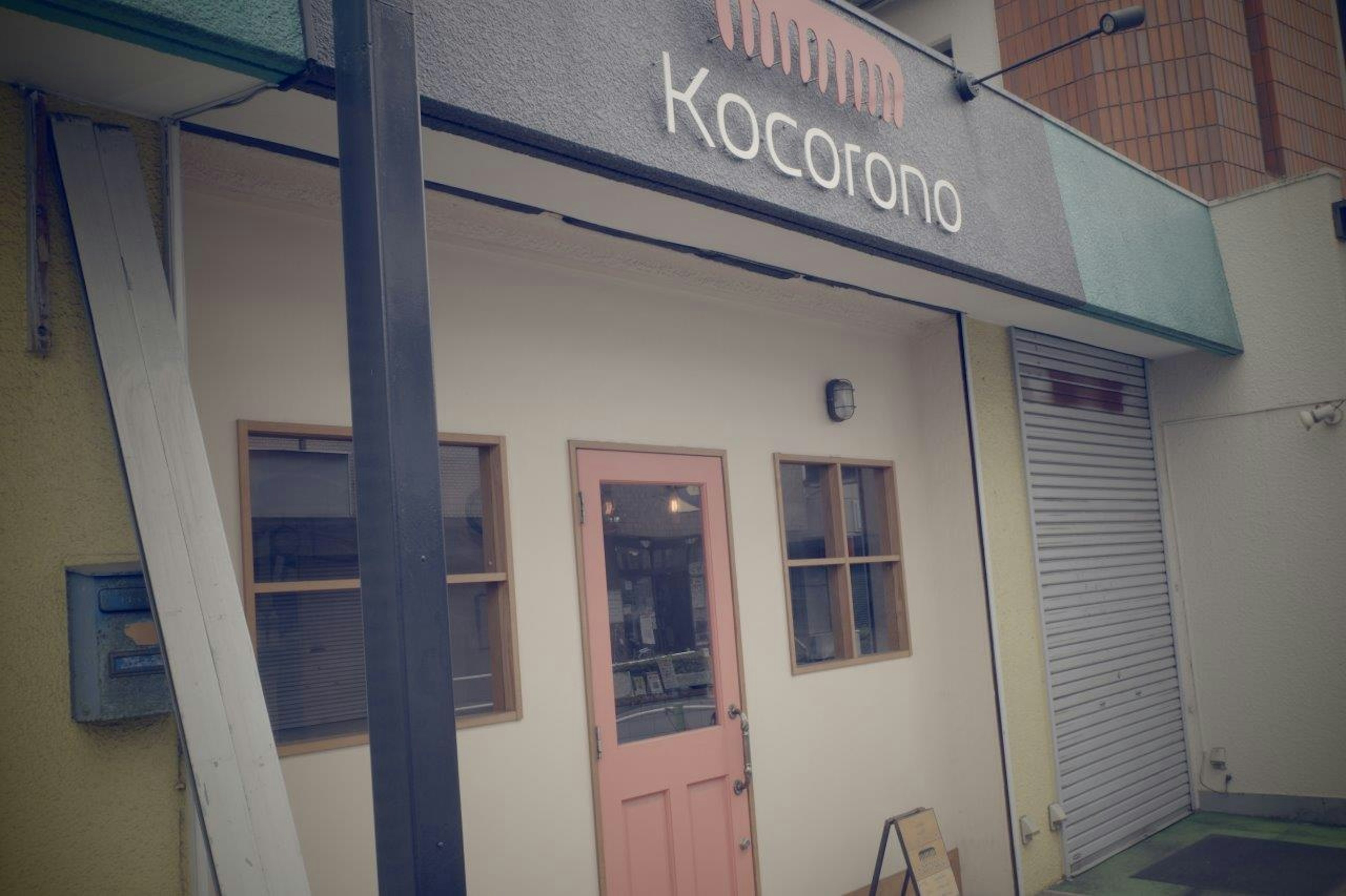 店舗の外観には「Kocorono」の看板があり、ピンクのドアと窓が特徴的