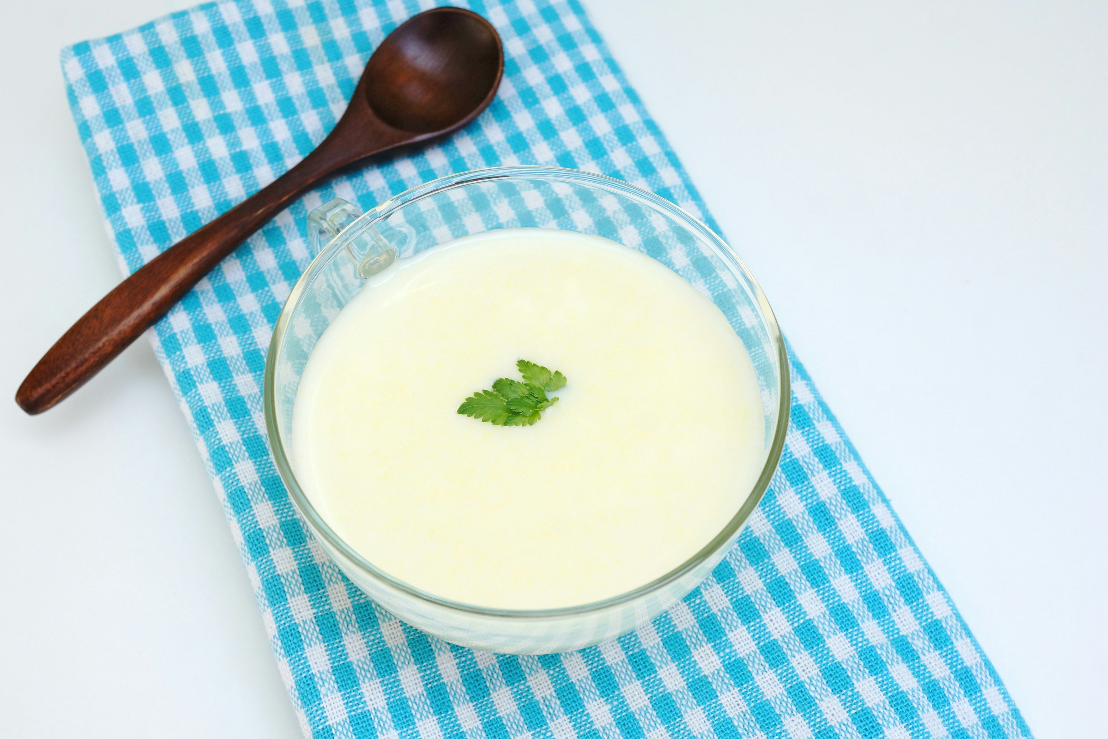 Postre cremoso en un tazón de vidrio con una hoja de menta encima