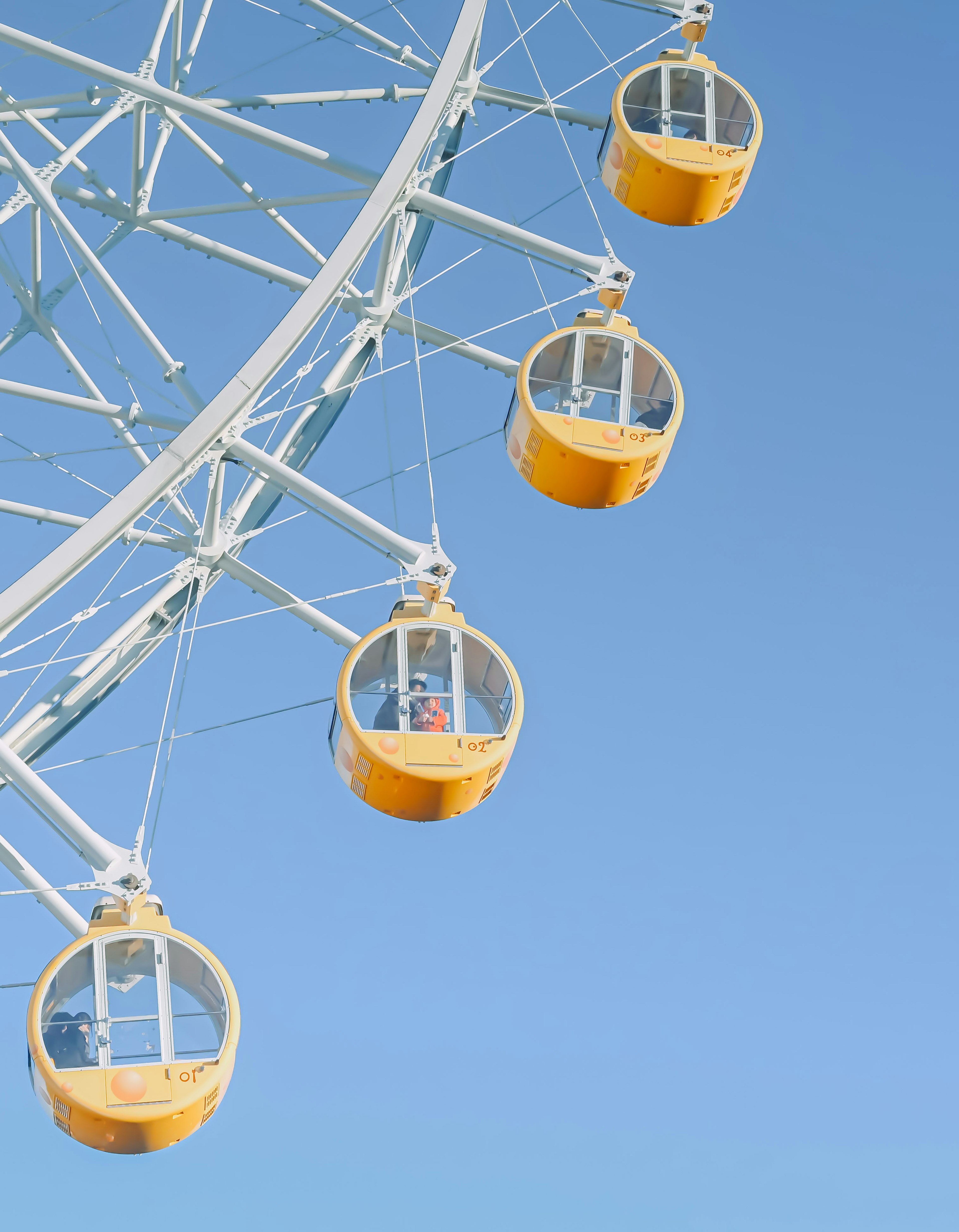 Grande roue avec des cabines jaunes sur fond de ciel bleu