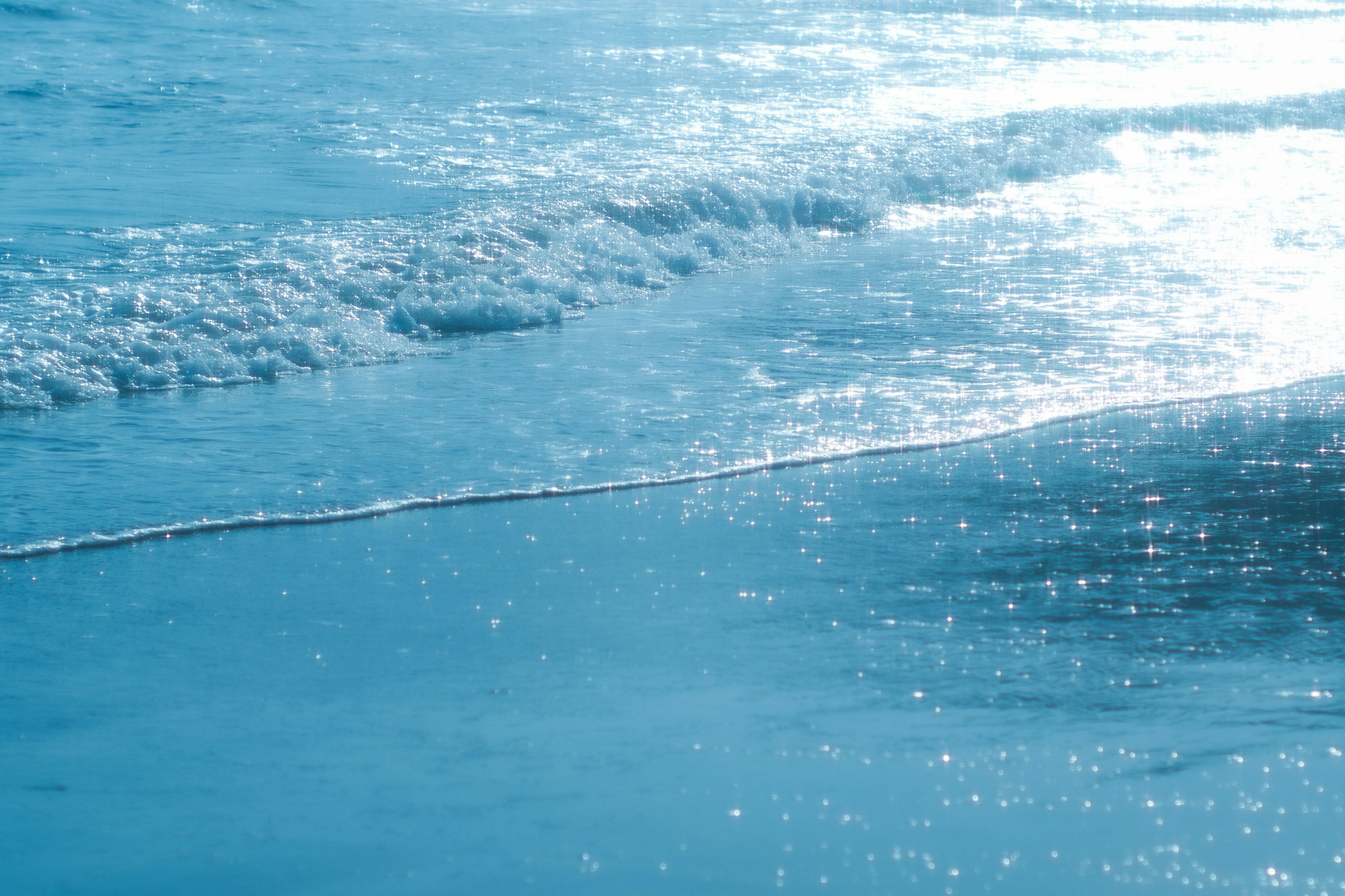 Olas oceánicas azules brillando bajo el sol