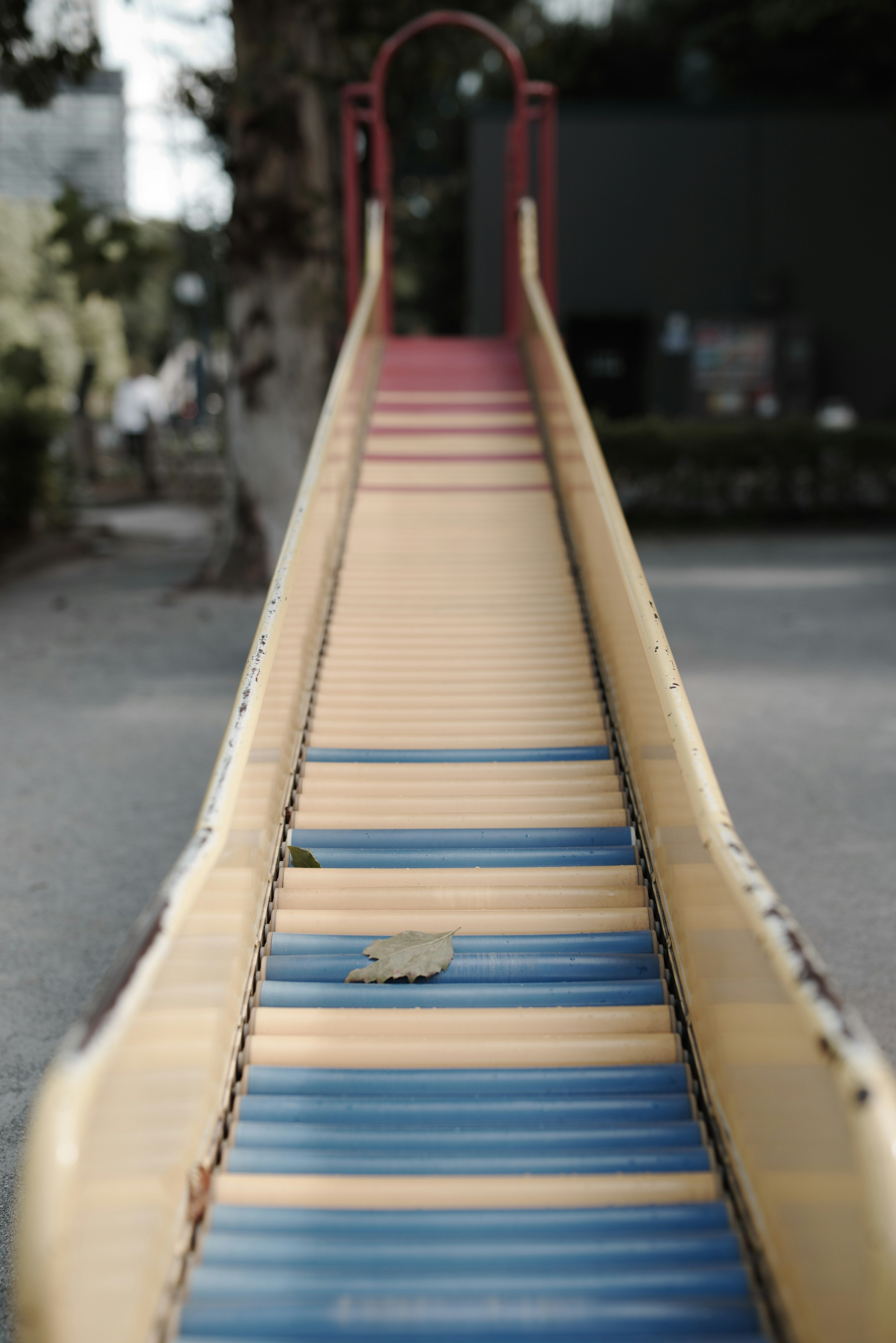 View of a playground slide featuring yellow and blue stripes