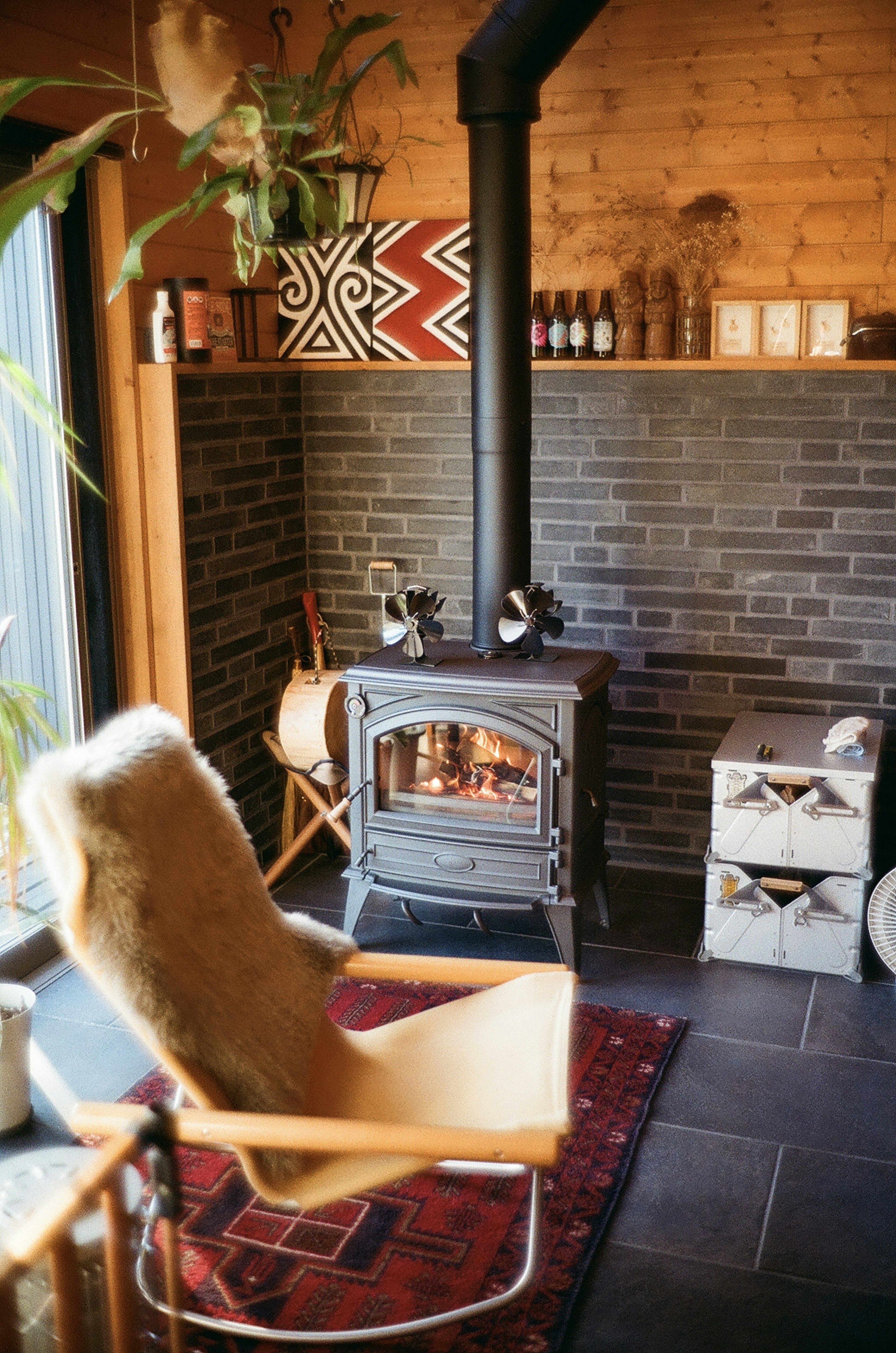 Cozy interior room featuring a wood stove and a reclining chair