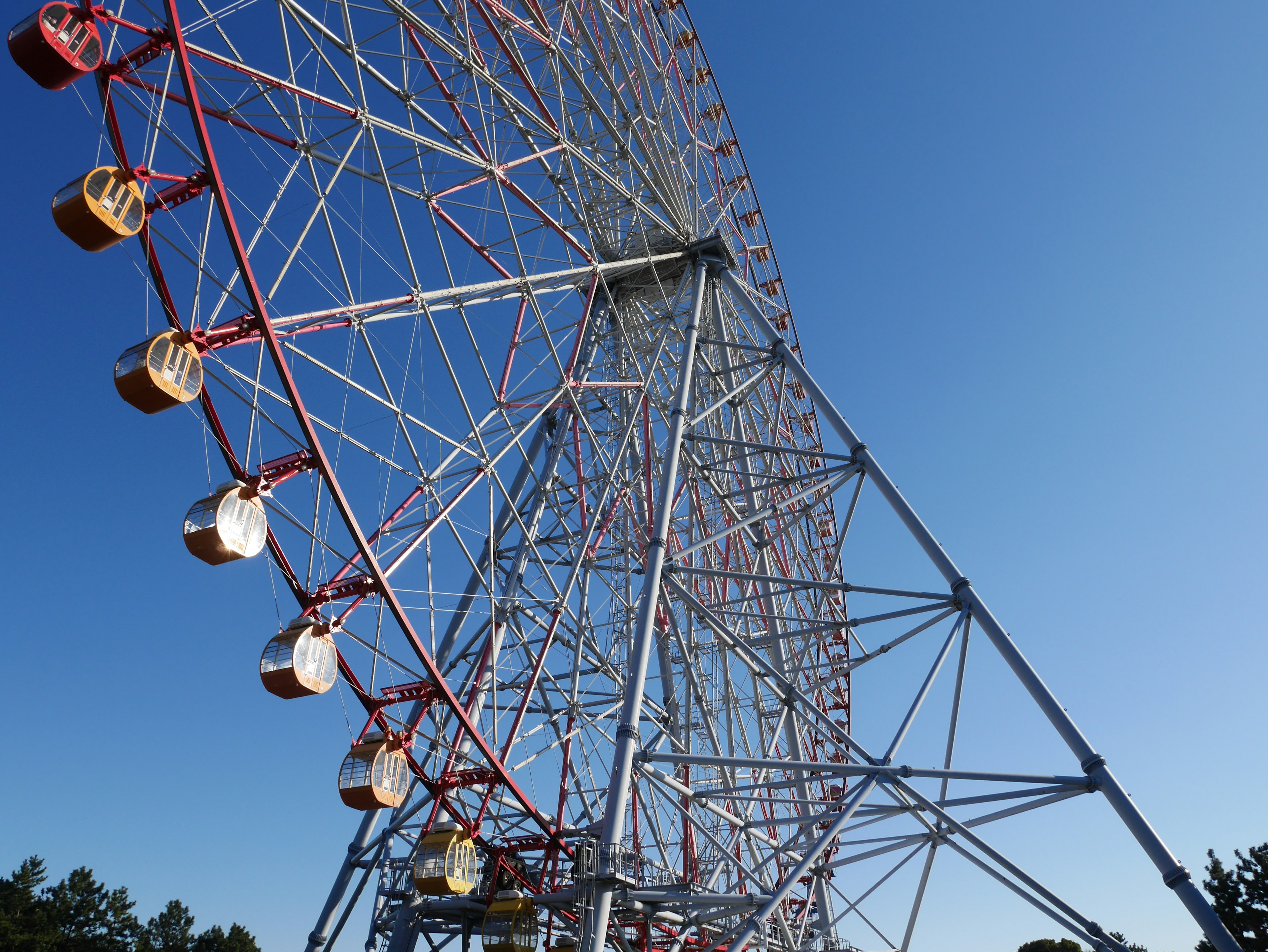 Ferris wheel structure with vibrant colors under clear blue sky